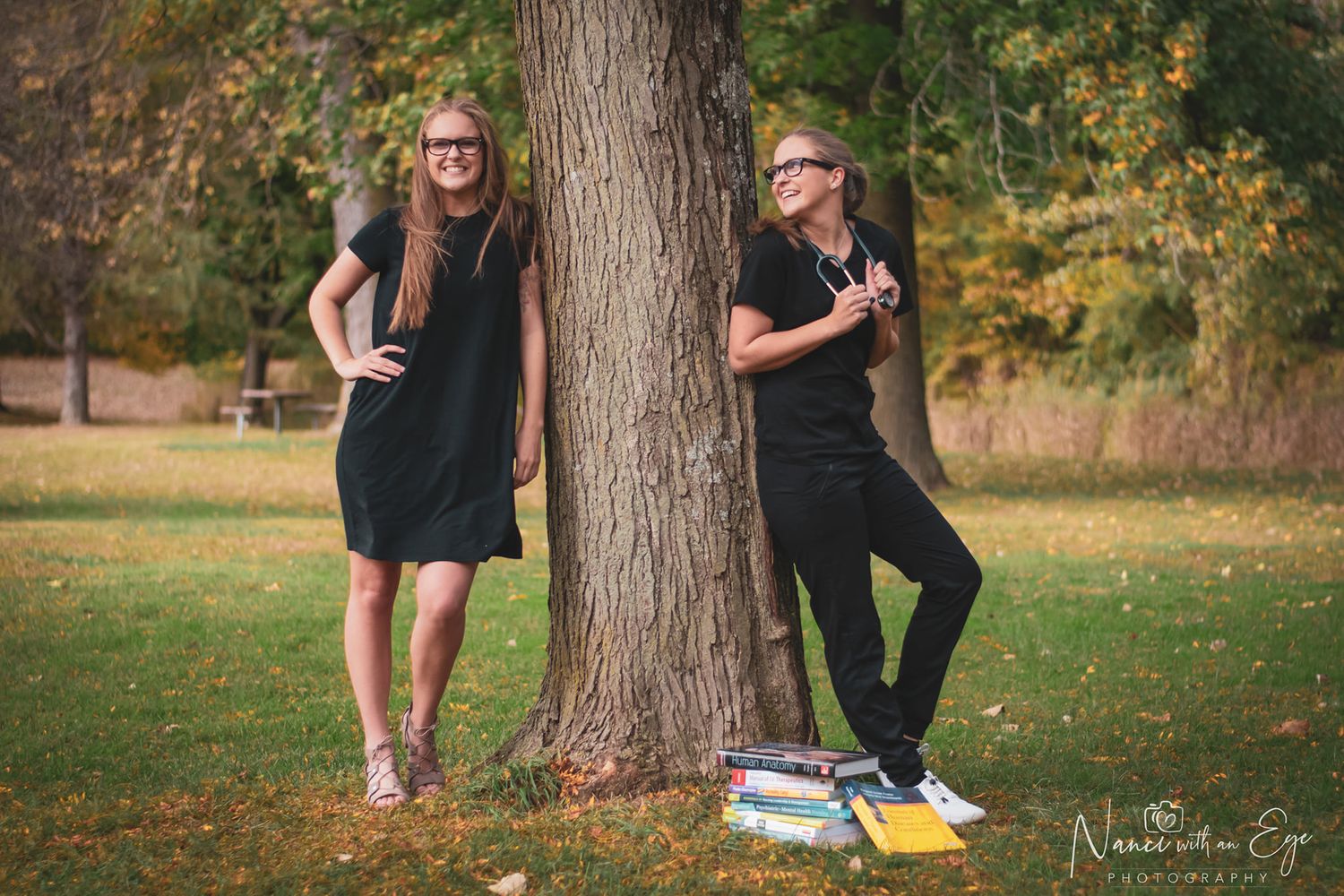 nursing senior photo of girl dressed in work clothes and dress next to a tree, fun and unique senior photo idea