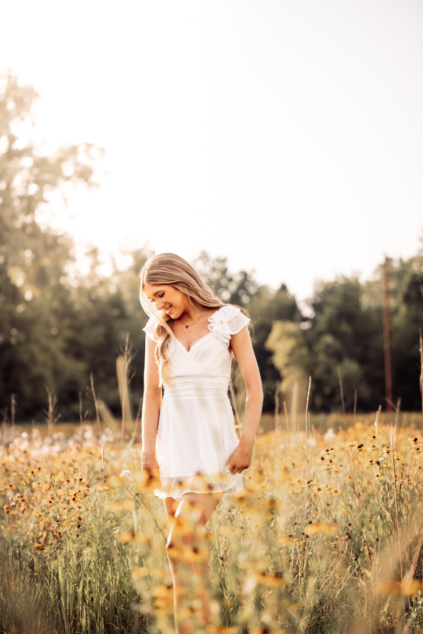 golden hour senior photo of girl in white dress in a field in the fall autumn