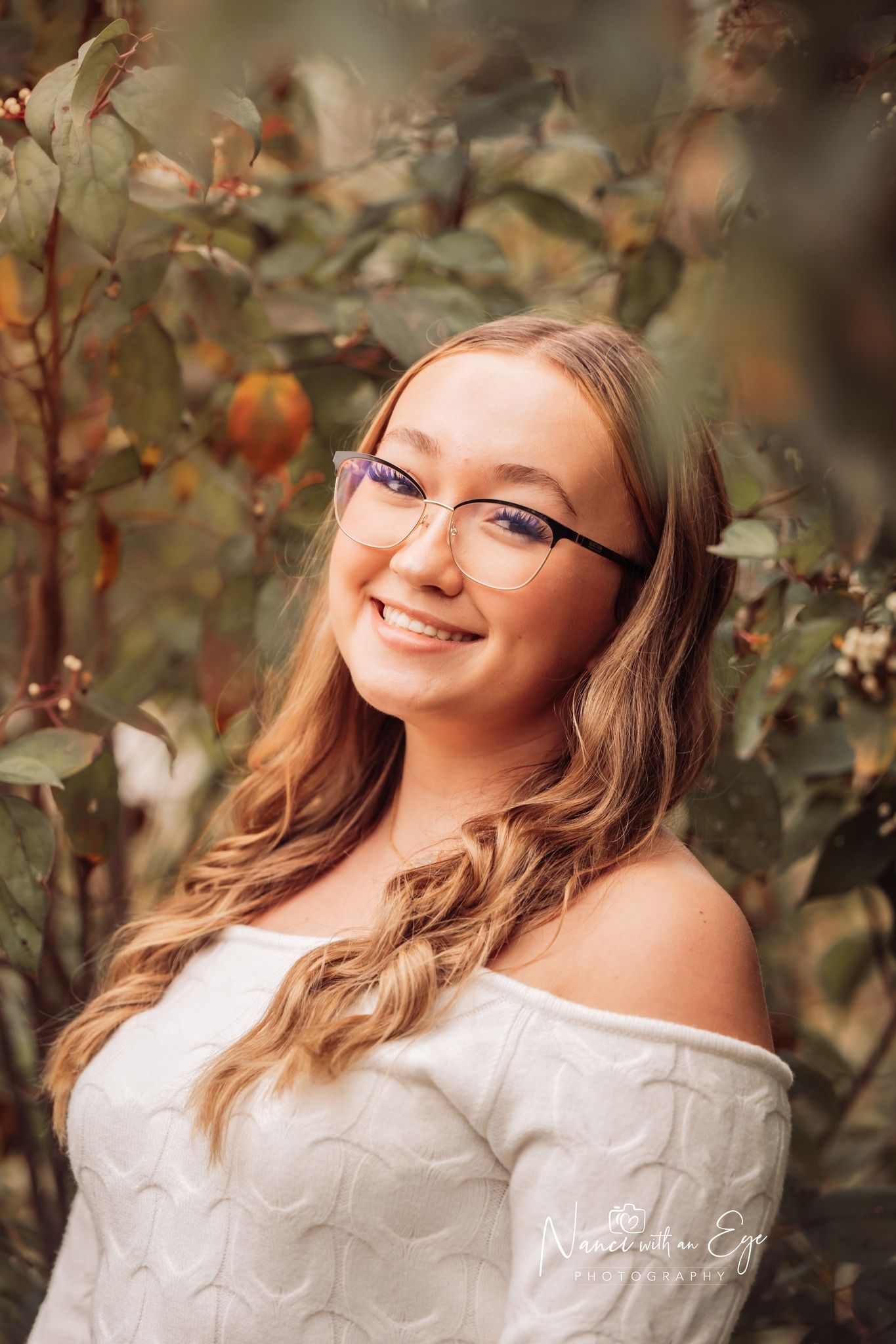 senior photo next to tree leaves