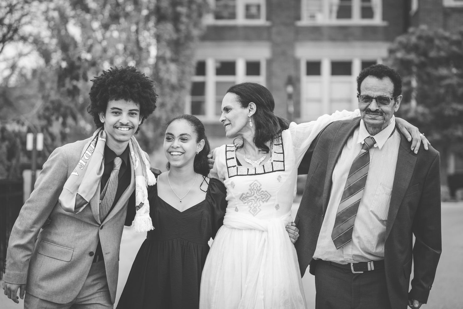 adult graduate celebrating graduation with family of four college senior photos