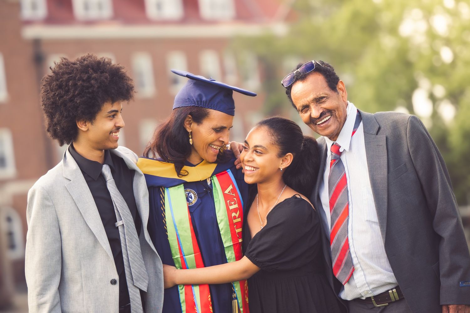 adult graduate celebrating graduation with family of four college senior photos