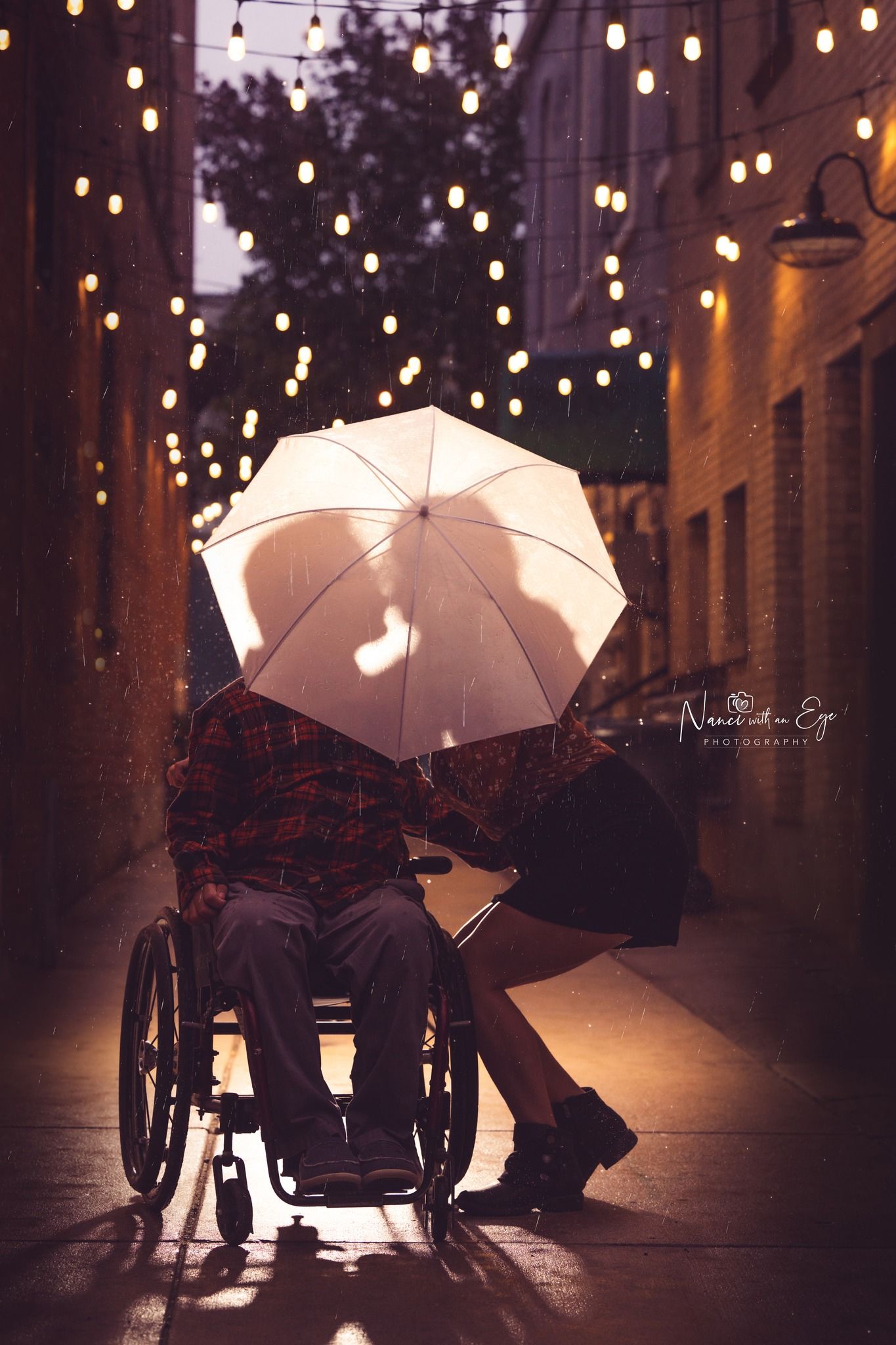 engagement photoshoot an night in the rain in an ally with lights wheelchair