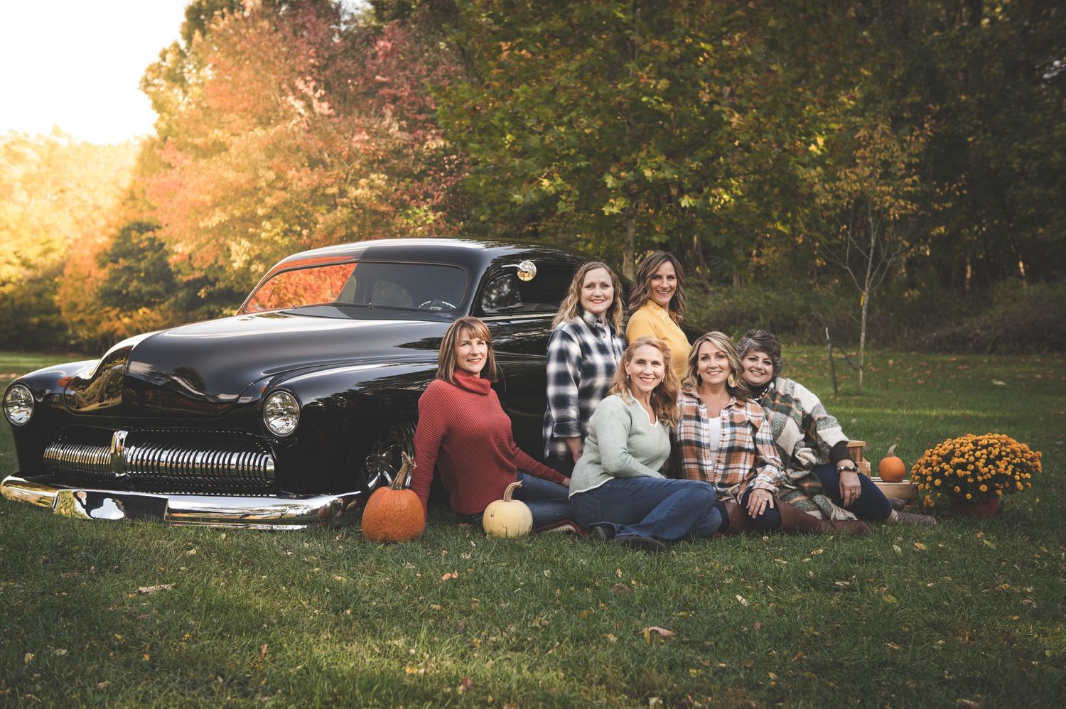 photo of sisters with oldsmobile old black car in the fall autumn