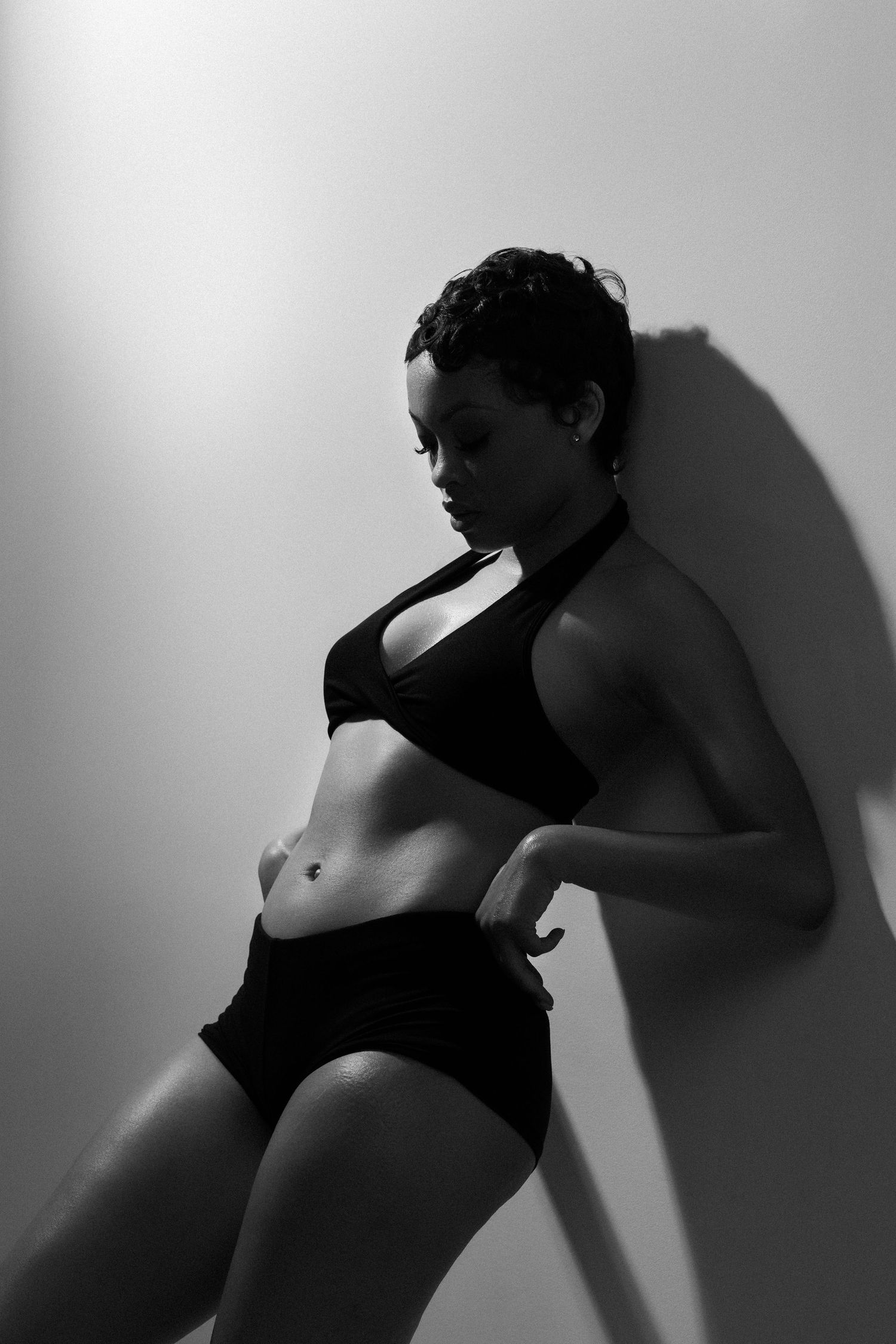 Dramatic black and white silhouettes capturing curves and movement in a studio setting.