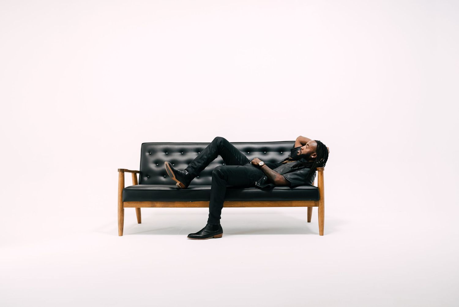 Artistic black and white studio portraits showing someone reclining on modern furniture.