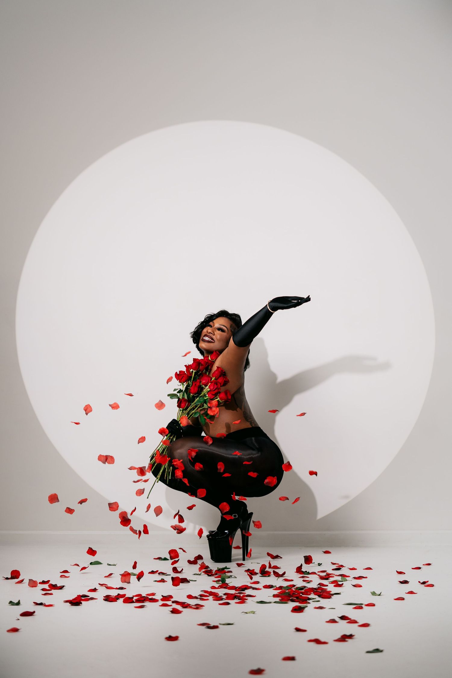Dramatic photo sequence with rose petals scattered on white backdrop in artistic poses.