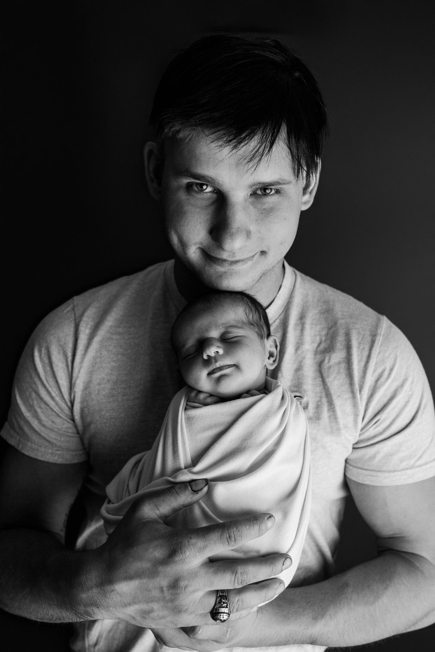 Intimate black and white portrait of parent and sleeping newborn.