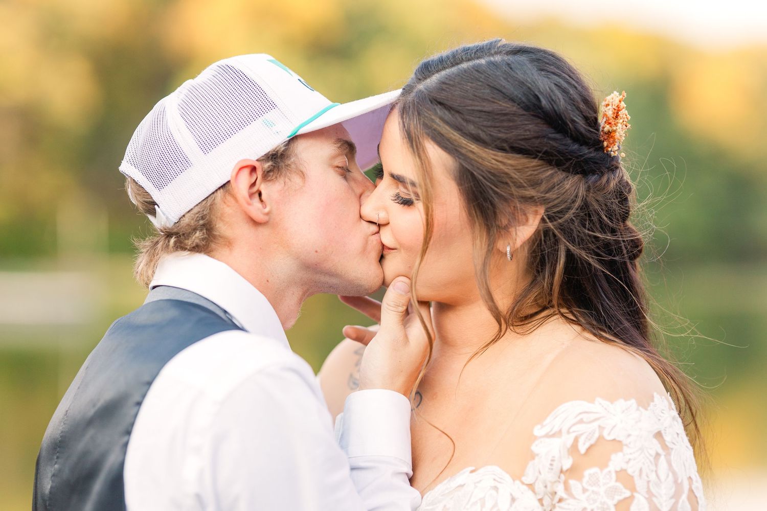 Romantic wedding couple sharing a kiss at sunset.