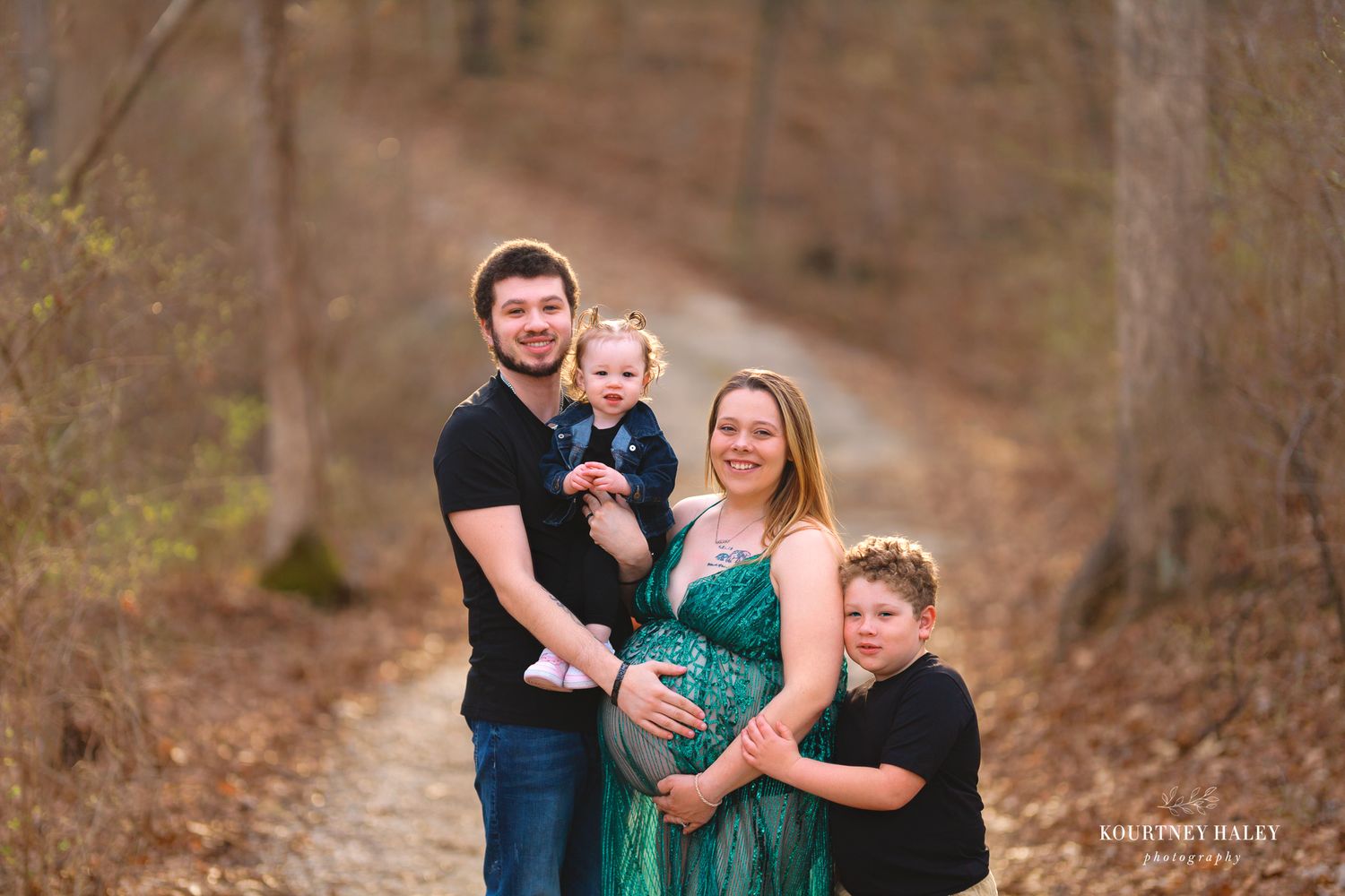 Outdoor family maternity portrait in the woods during autumn.