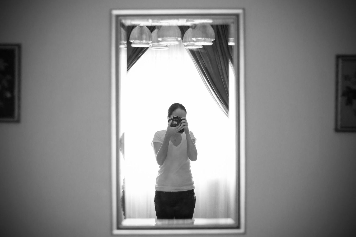 Three black and white portraits capture a person posing with dramatic window lighting in minimalist compositions.