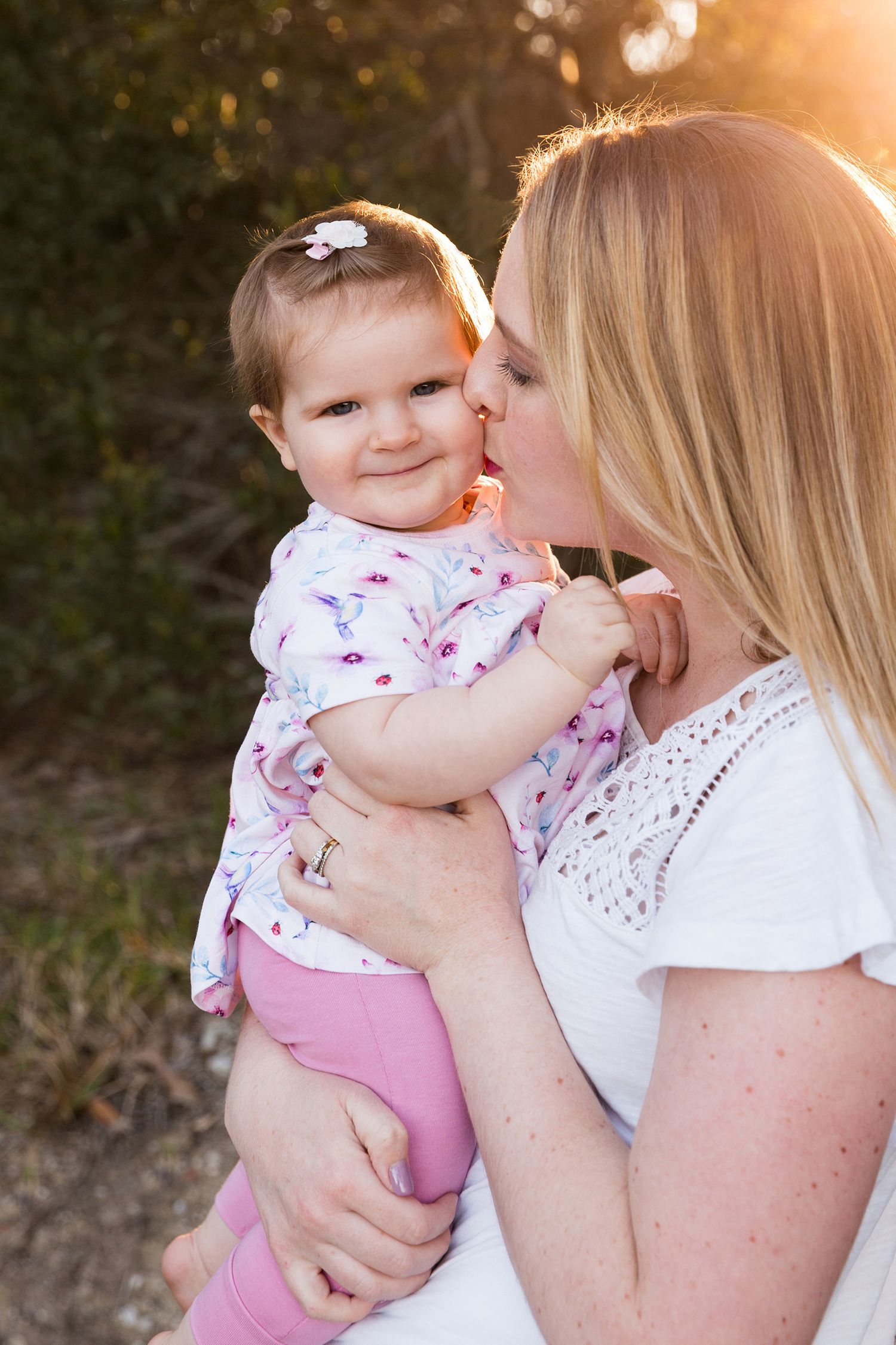 A parent and baby share tender moments at sunset in a series of four connected photos.