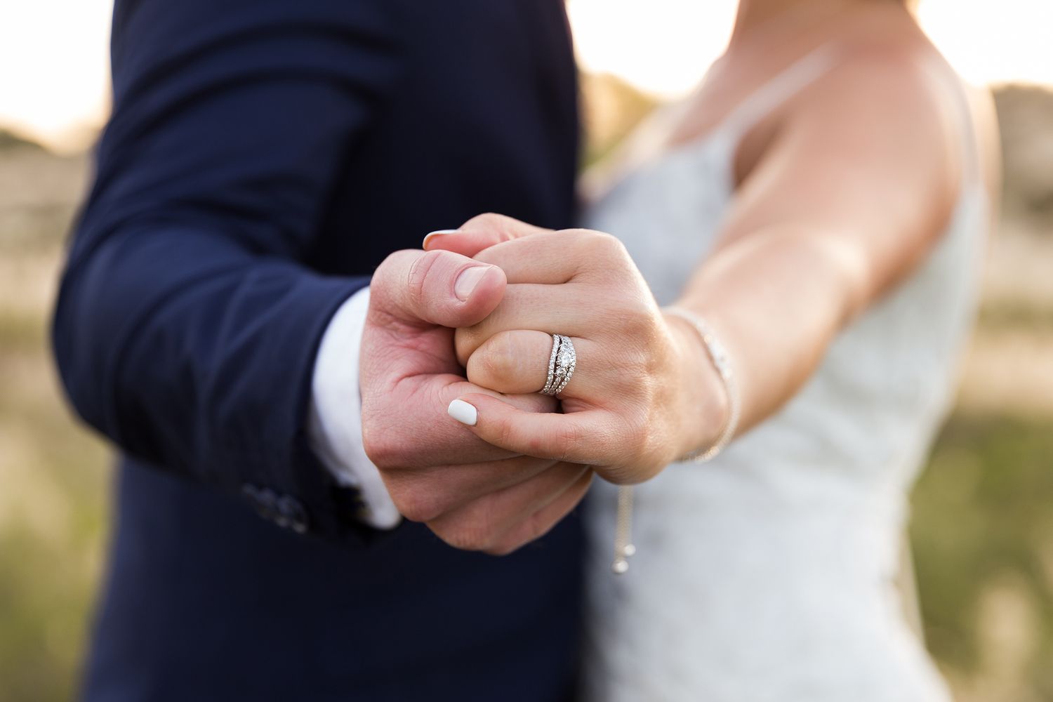 A close-up of hands exchanging wedding rings during a marriage ceremony.