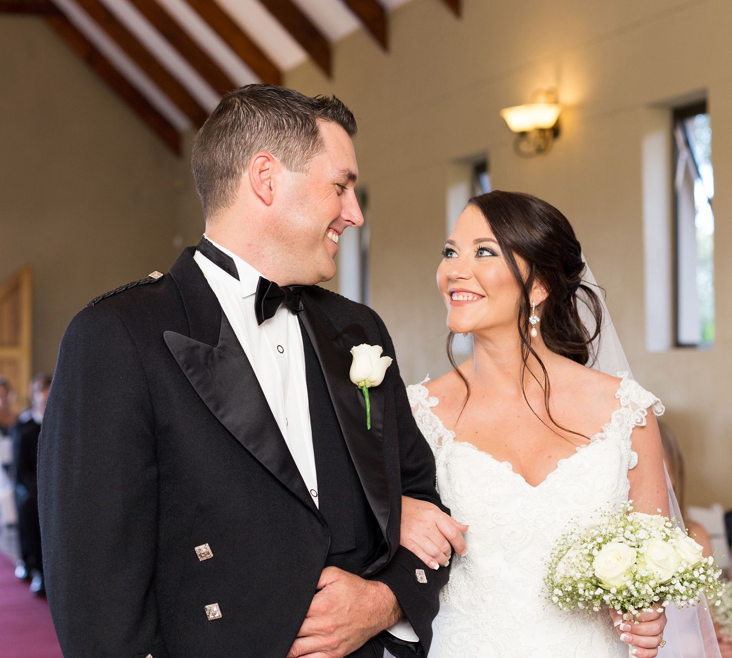 Wedding couple sharing intimate moments while dancing in an elegant reception venue with warm lighting.