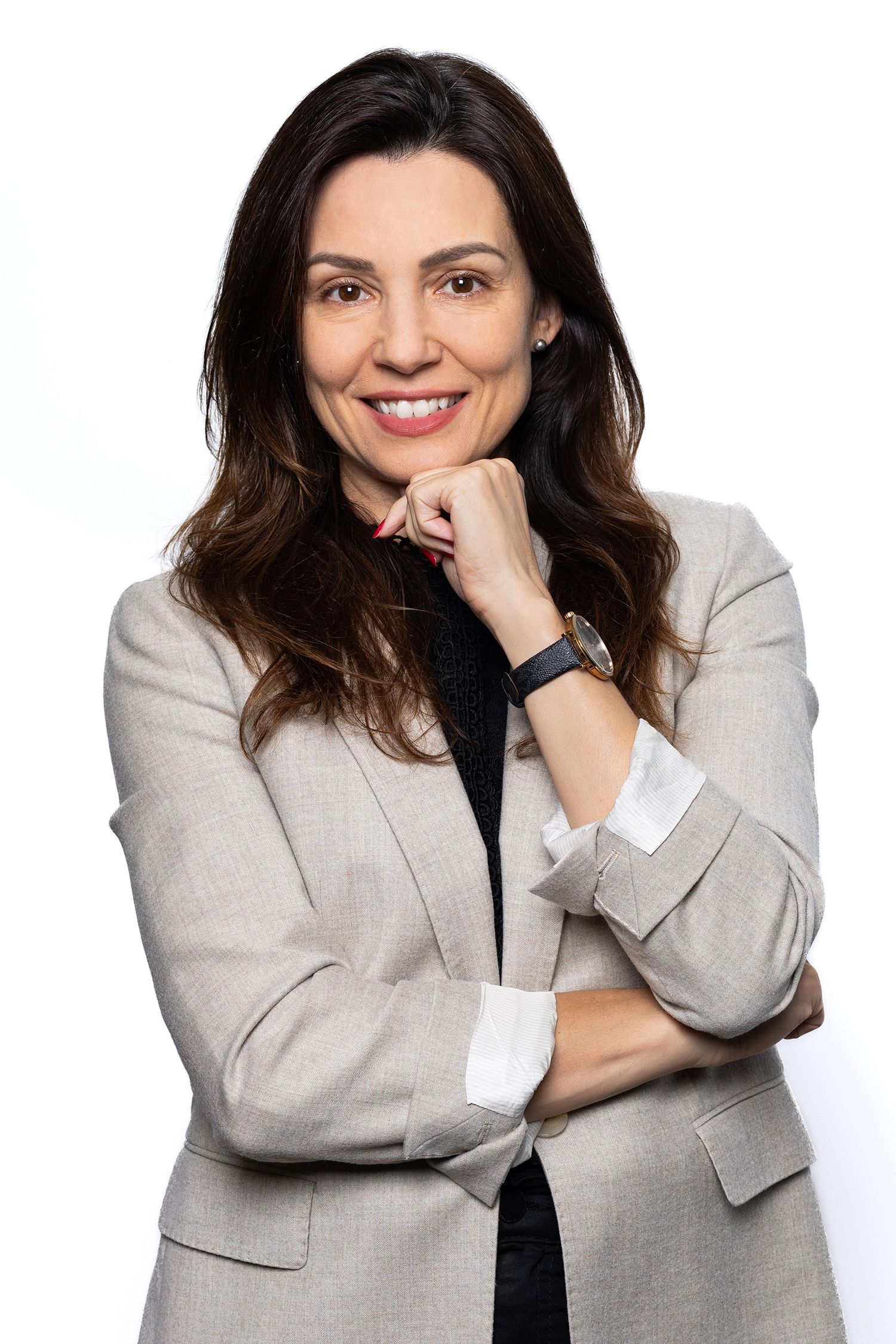 A person in a light gray blazer and black top poses in a series of playful expressions against a white background.