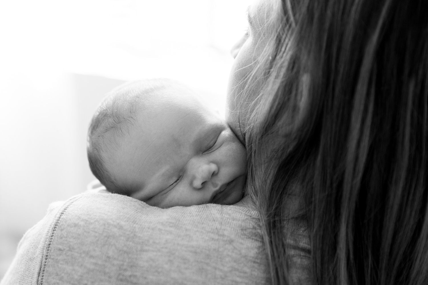 A tender moment captured in black and white shows an intimate bonding scene between parent and child.