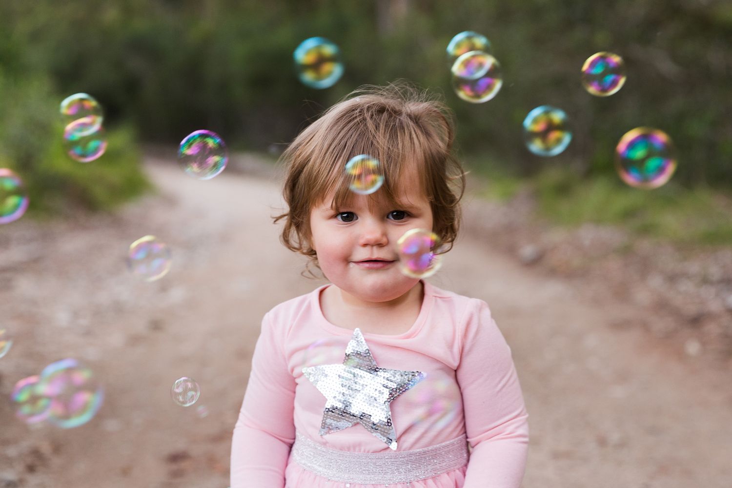 Colorful soap bubbles float in the air through multiple photo frames capturing a magical outdoor moment.