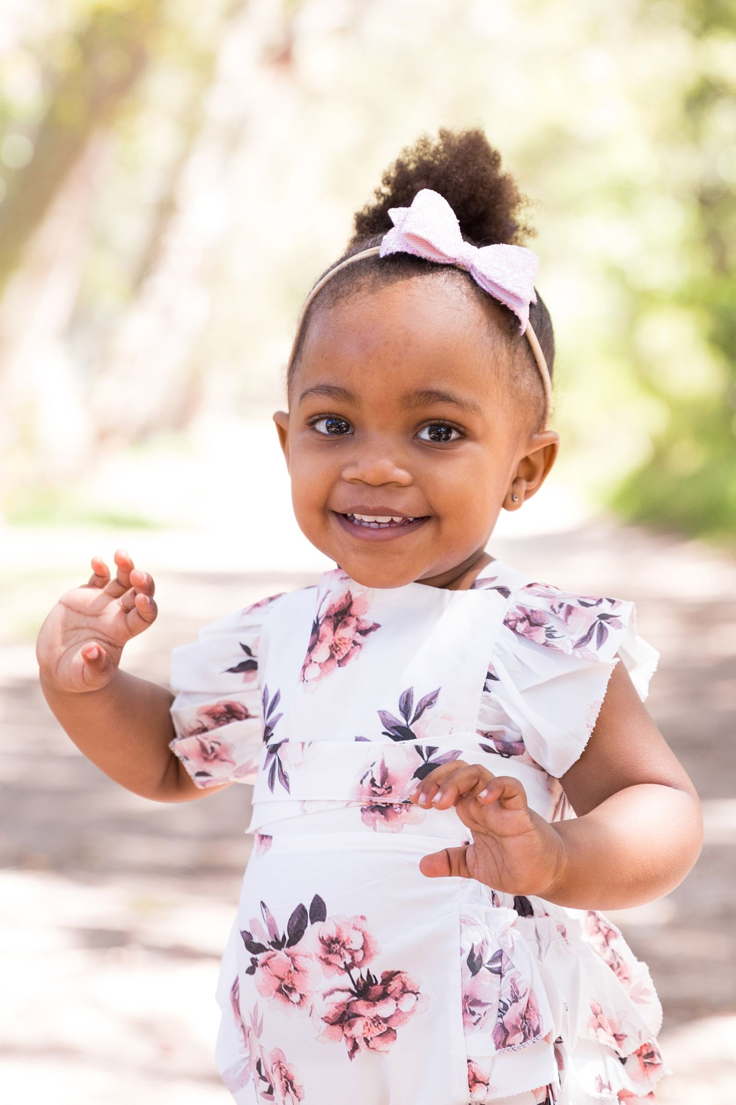 A floral clothing set with ruffles and design details laid out on a soft beige background.