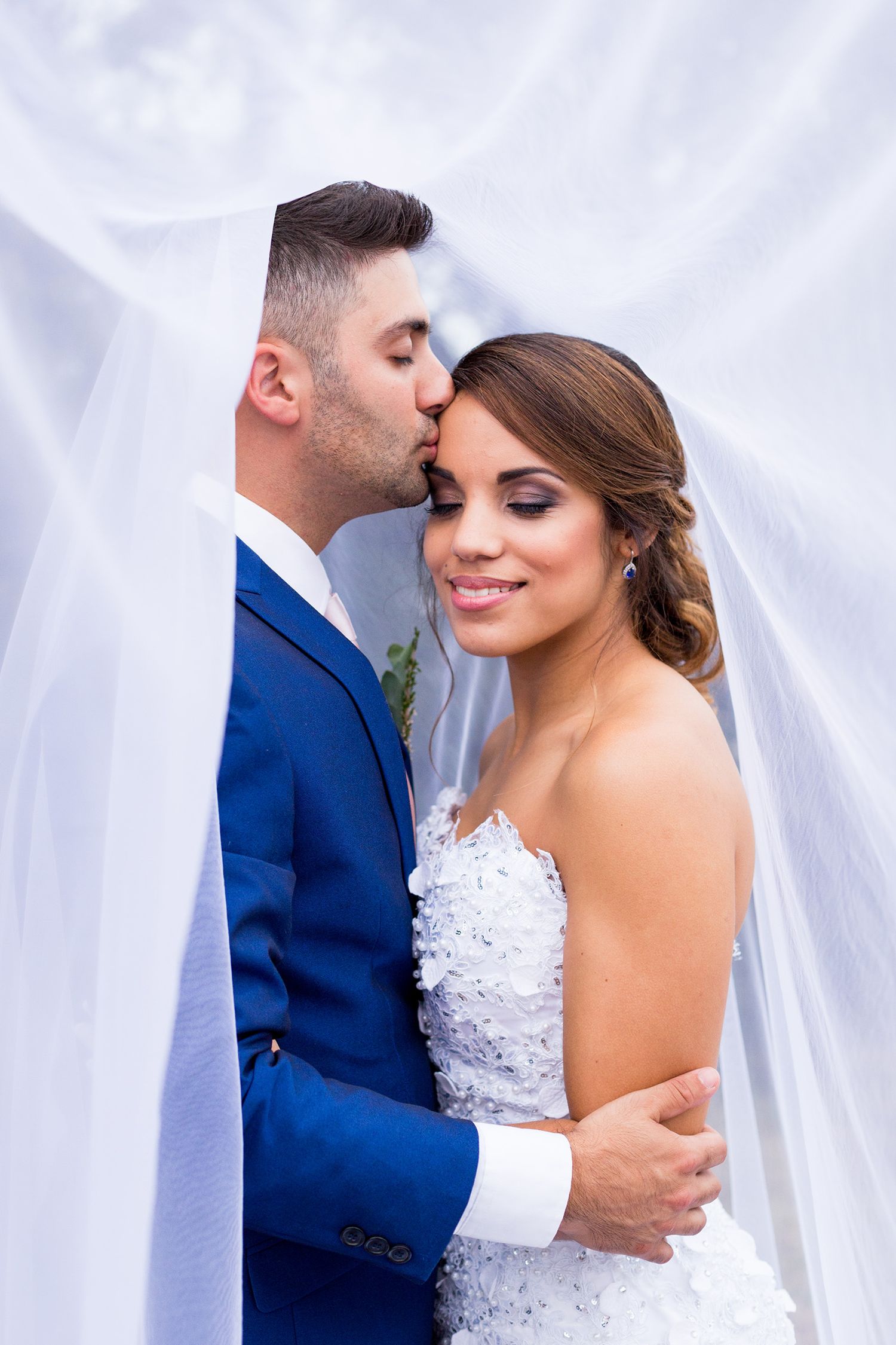 Romantic wedding portrait sequence showing intimate moments between newlyweds against white fabric backdrop.
