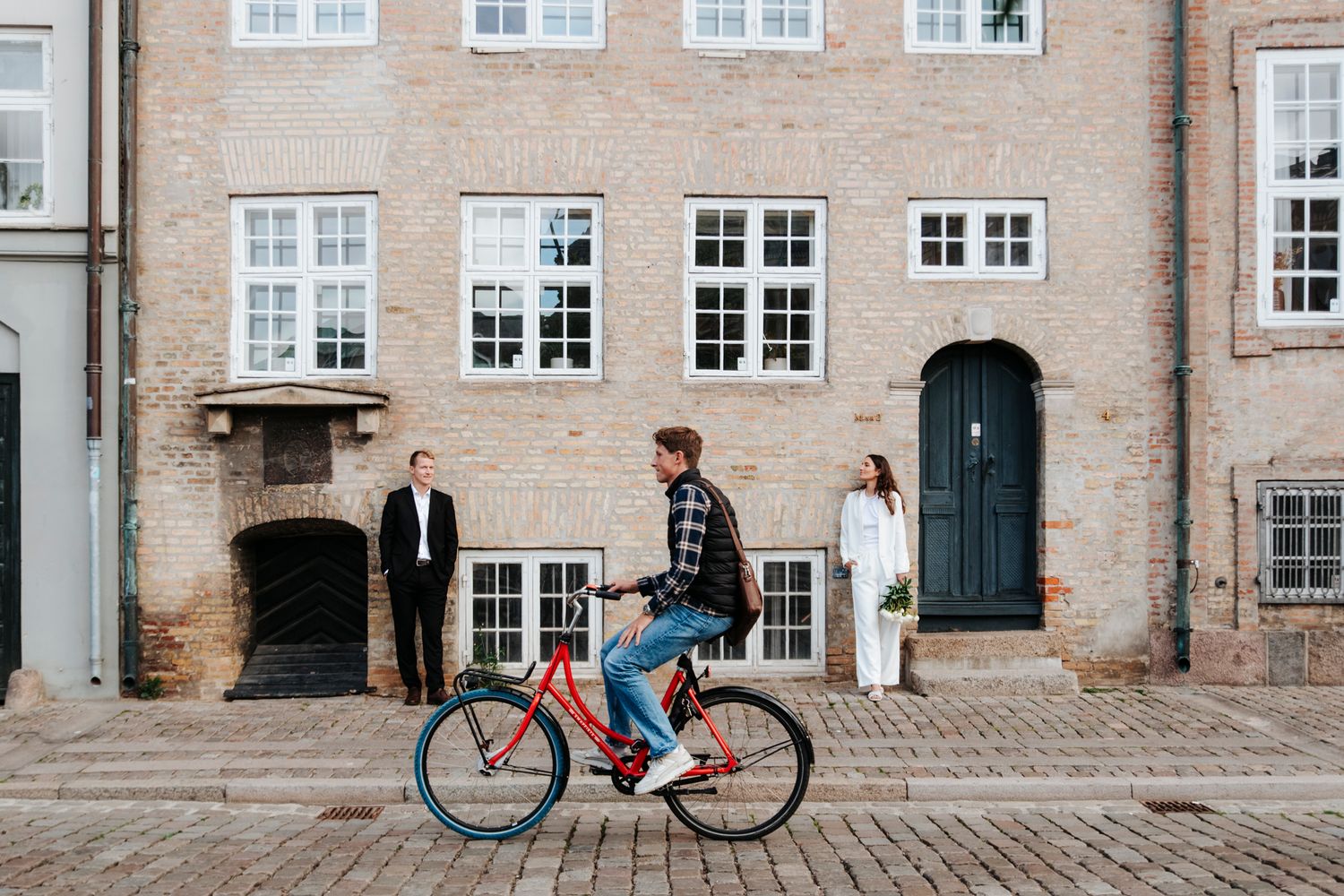 A cobblestone courtyard surrounded by traditional brick buildings with white windows.