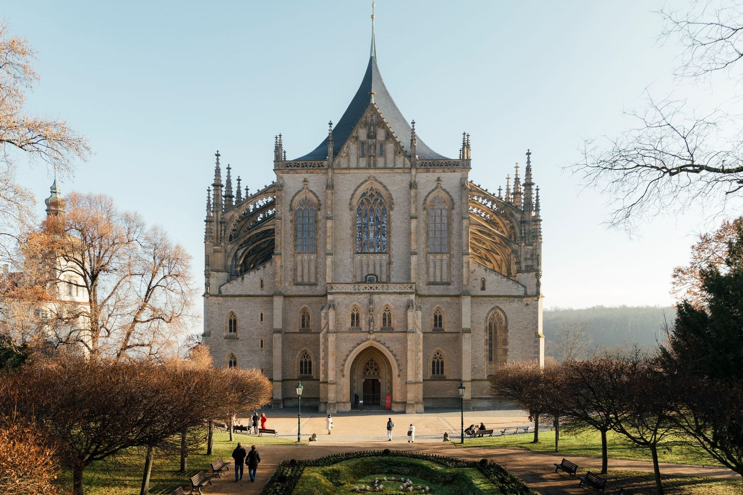 Gothic cathedral exterior with spires photographed against blue sky in autumn setting.