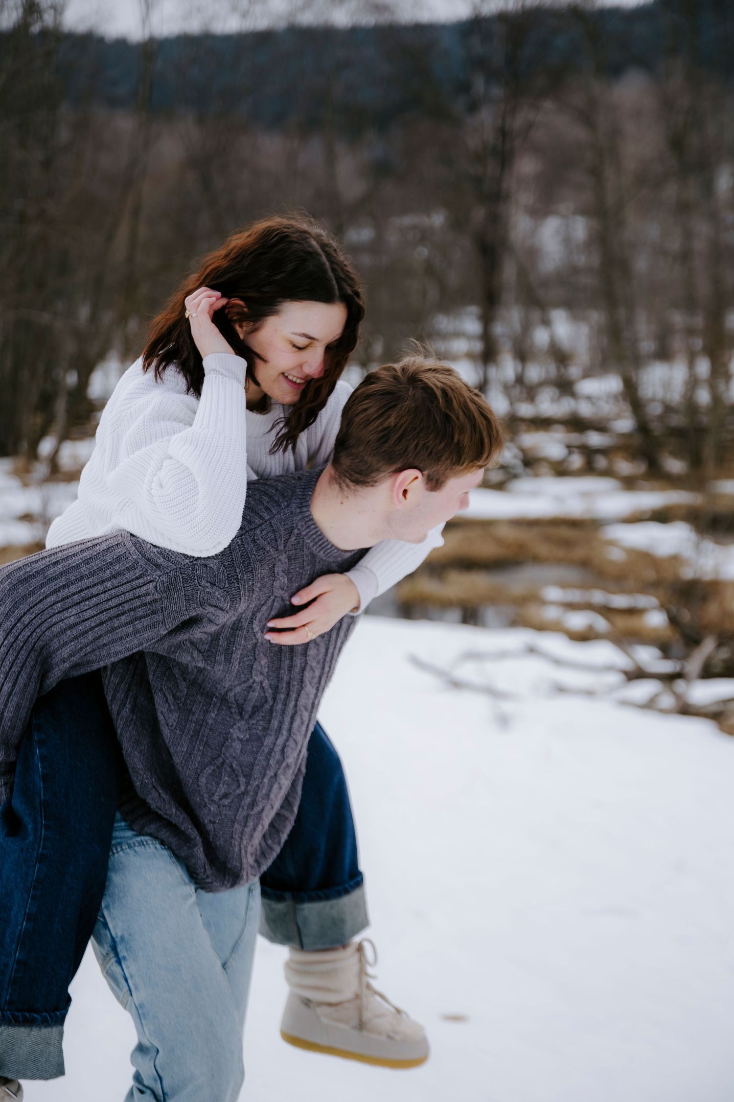 Playful winter moment with person being carried piggyback style in the snow.