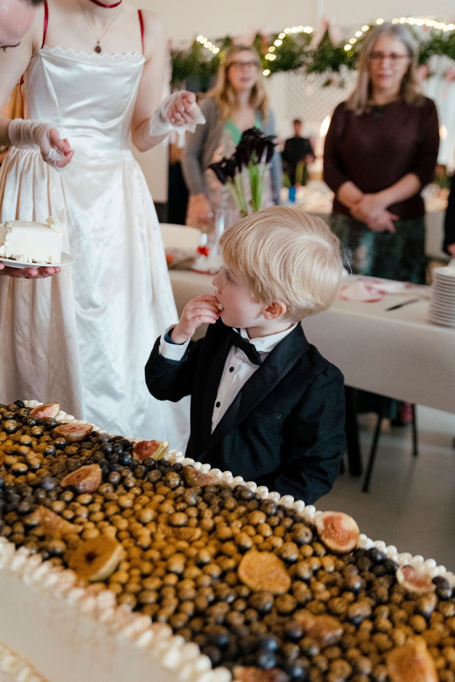 An elegant dessert table at a wedding reception displays an assortment of cookies and treats arranged in rows.
