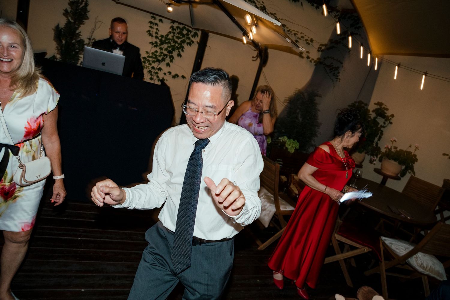 Wedding guests enjoying themselves during an indoor reception celebration.