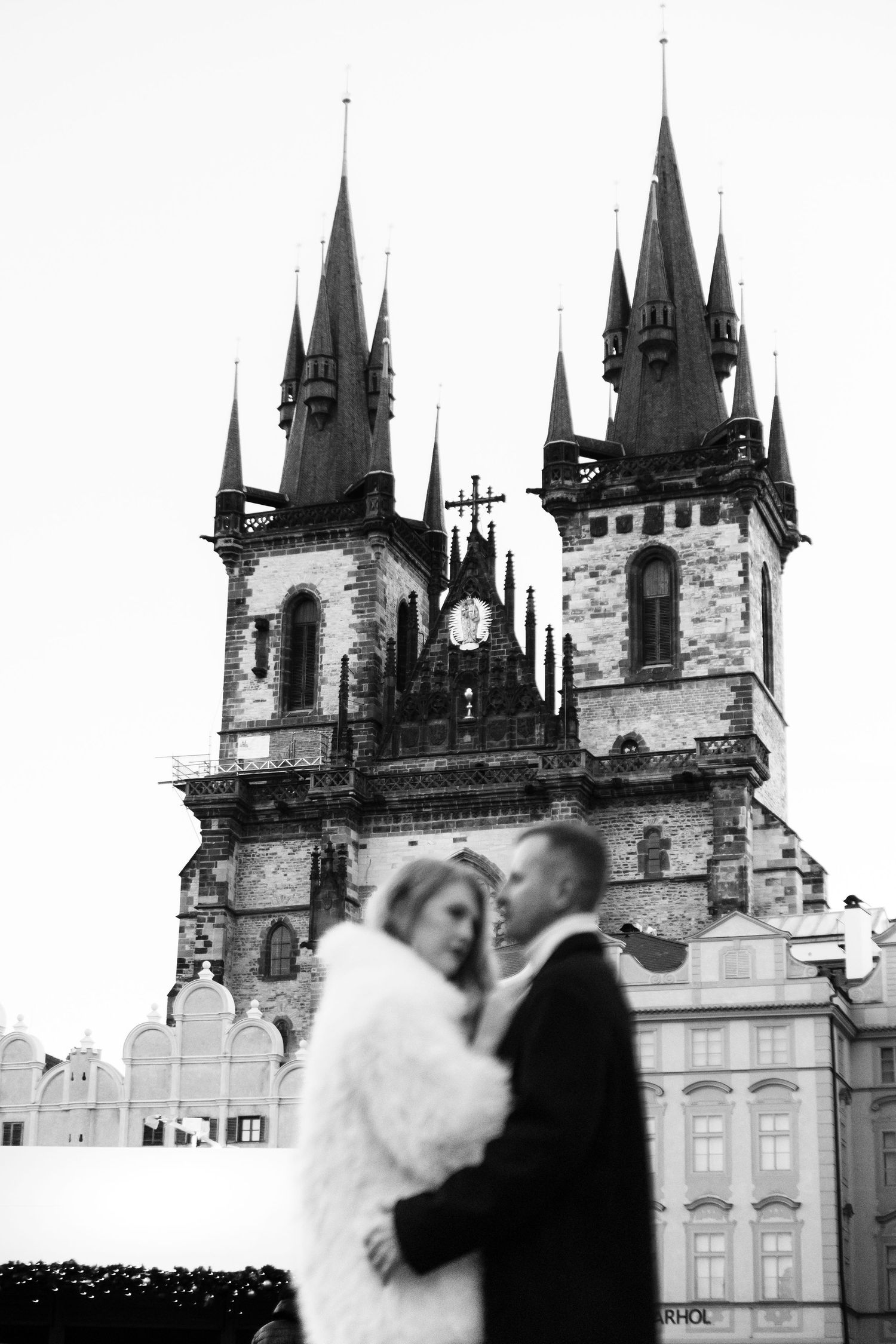 A romantic wedding photo in black and white featuring the iconic Church of Our Lady before Týn in Prague.