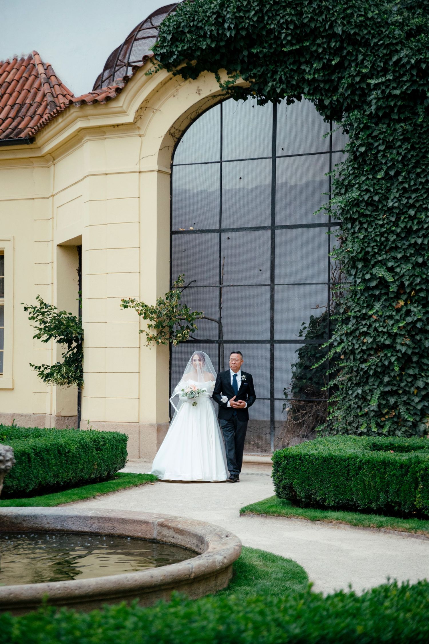 Wedding venue exterior featuring cream colored walls with ivy and large windows.