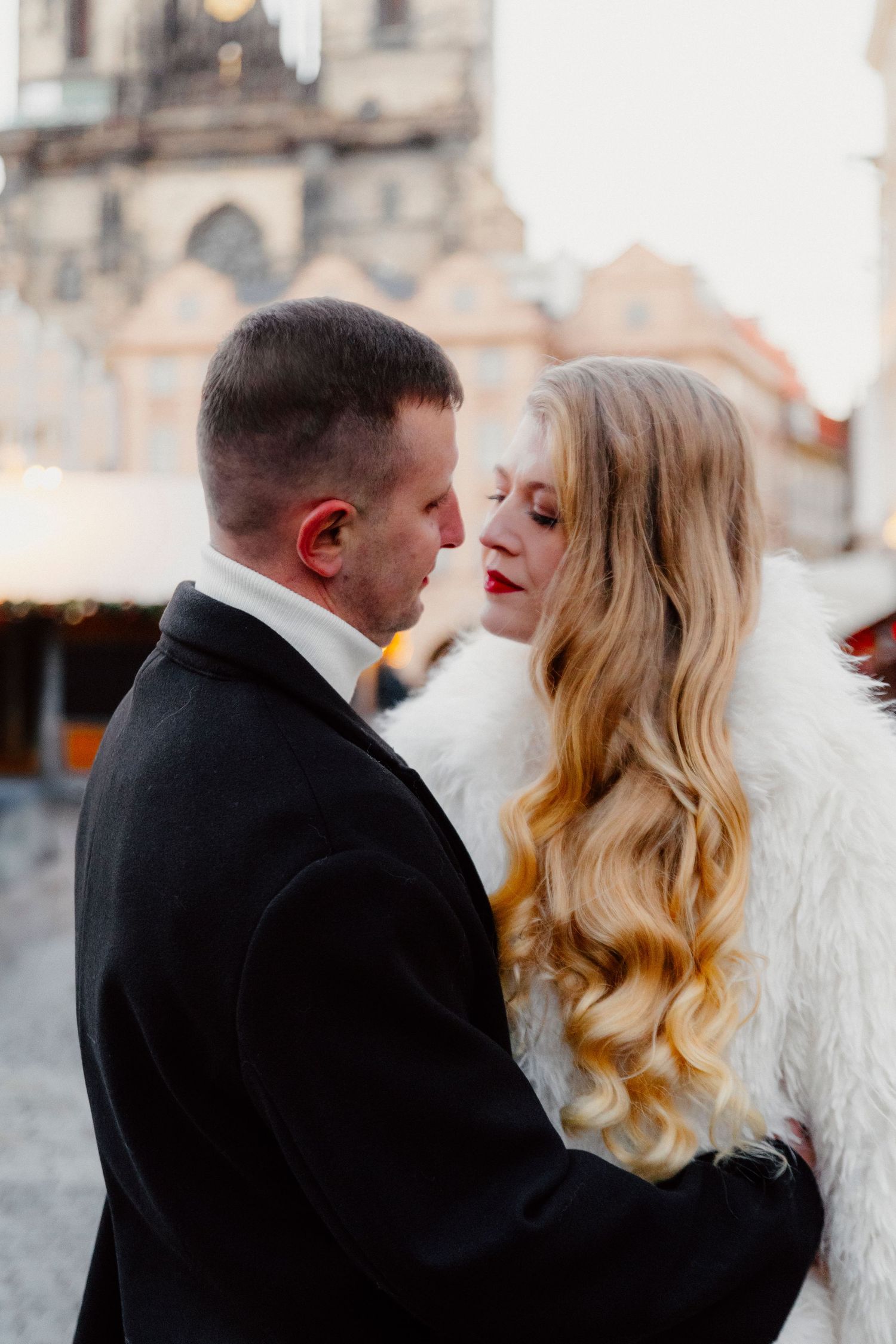 Romantic winter wedding portrait with couple in black suit and white fur coat.