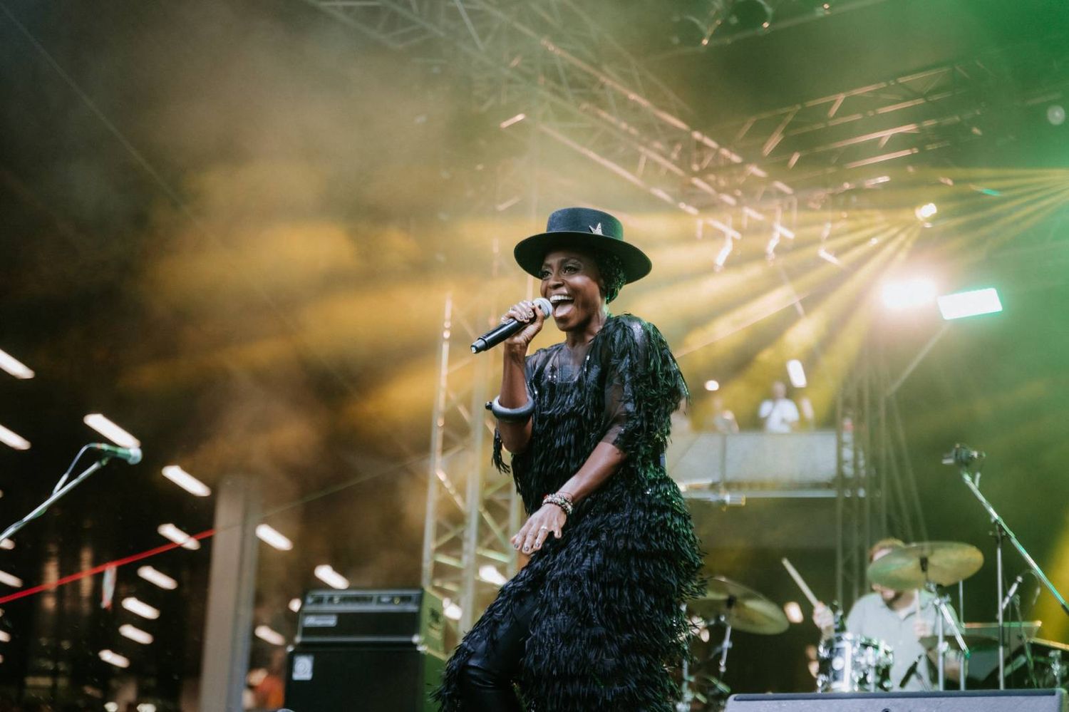 A musician performs on stage with dramatic lighting and fog effects during an energetic concert performance.