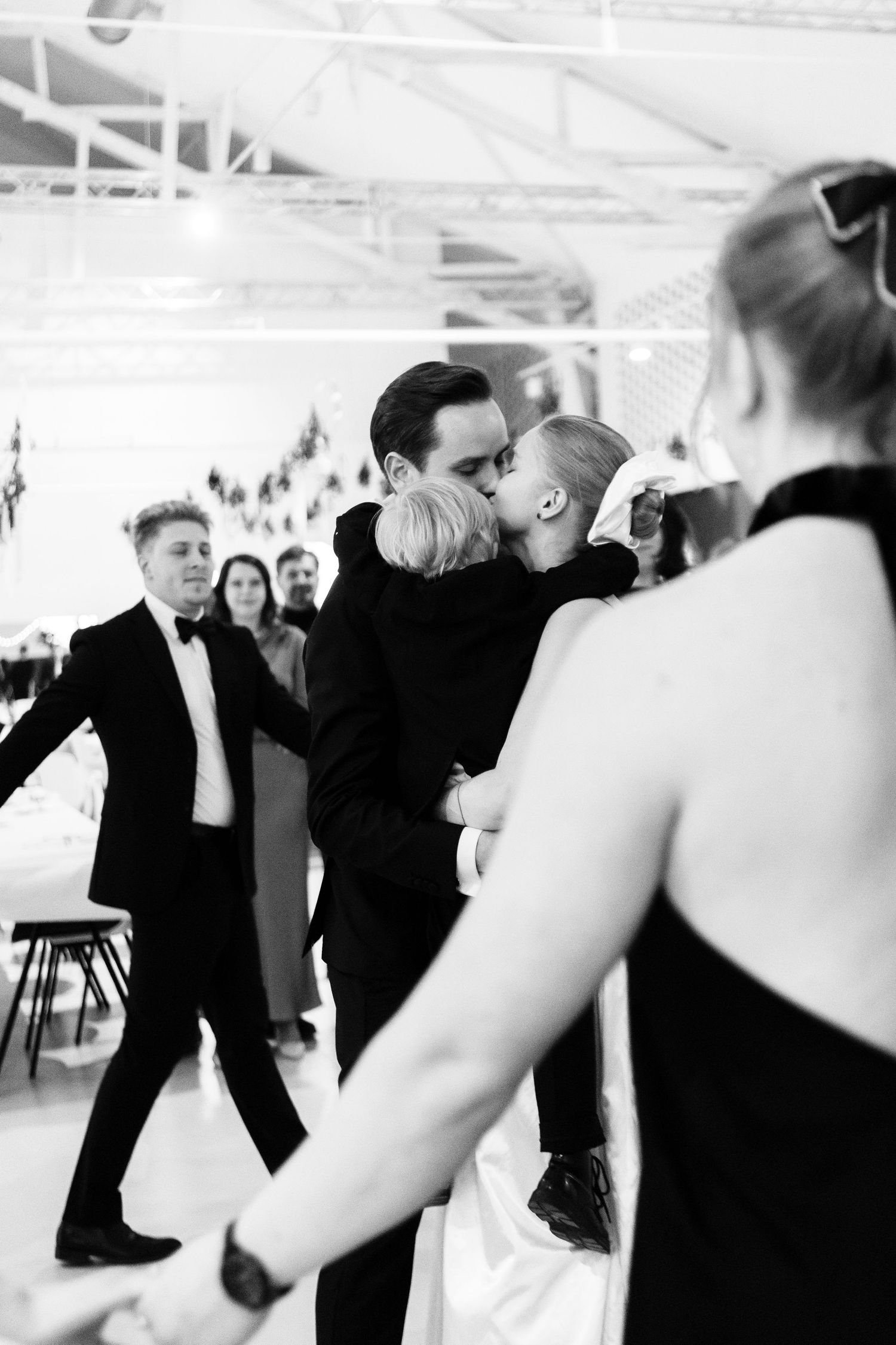 Wedding reception dance floor with guests in formal attire dancing in black and white.