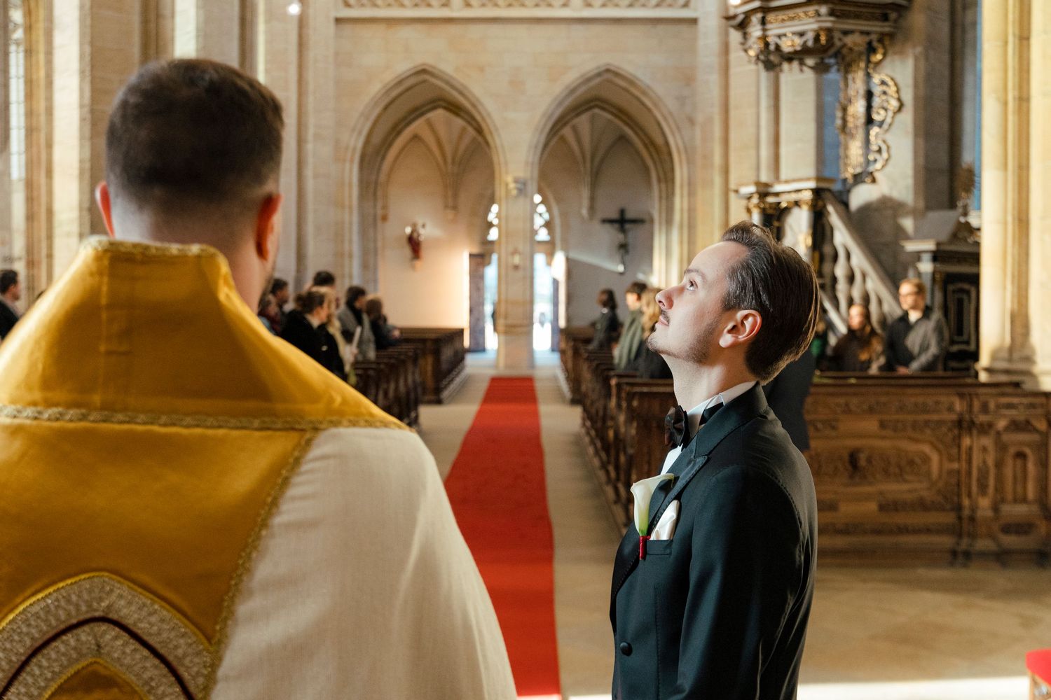 Wedding ceremony taking place in ornate cathedral interior with vaulted ceilings and architectural details.