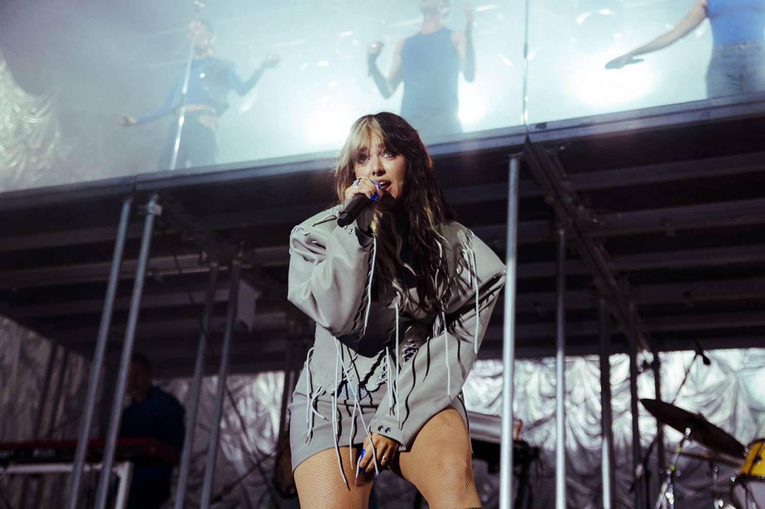 A performer sings passionately on stage during a live concert performance.