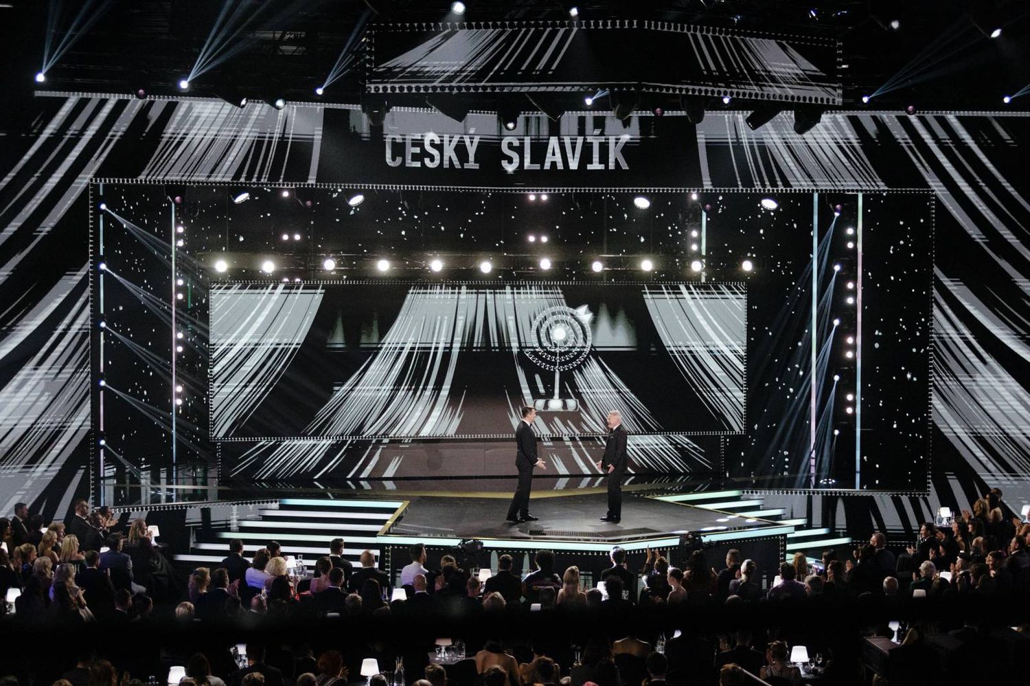 Wide concert stage setup with dramatic lighting design and 'Cesky Slavik' text display.