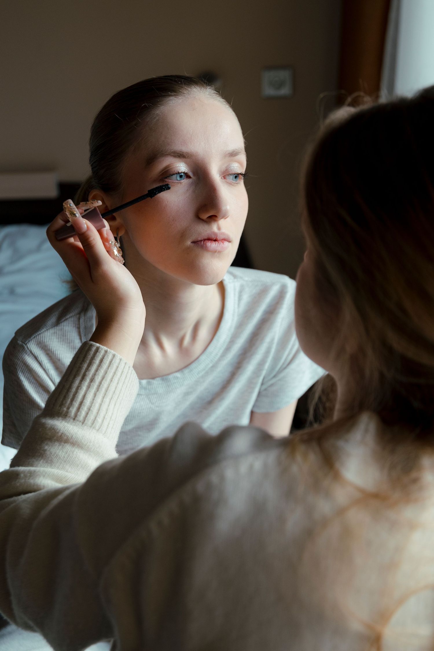 A sequence of makeup application shots showing mascara being applied in natural lighting.