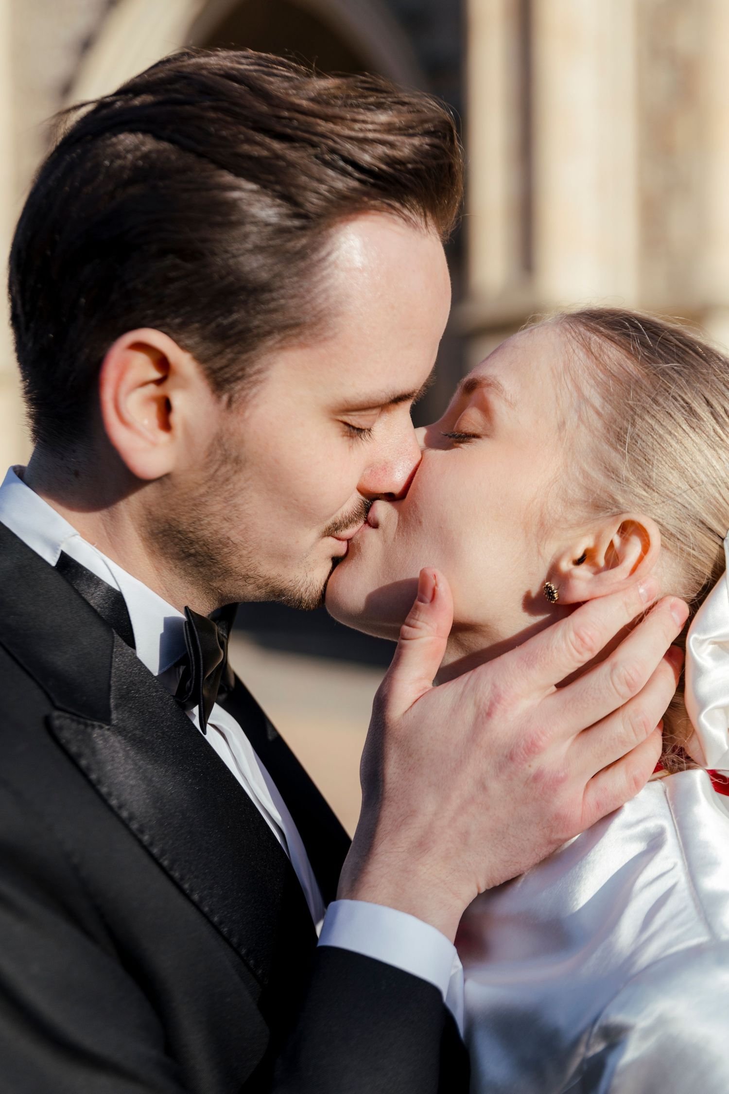 A romantic moment shared between newlyweds outside a historic building.