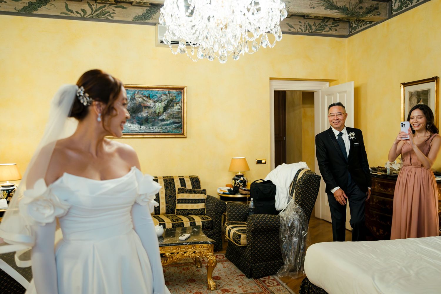 Interior of elegant wedding venue with crystal chandelier and yellow walls.