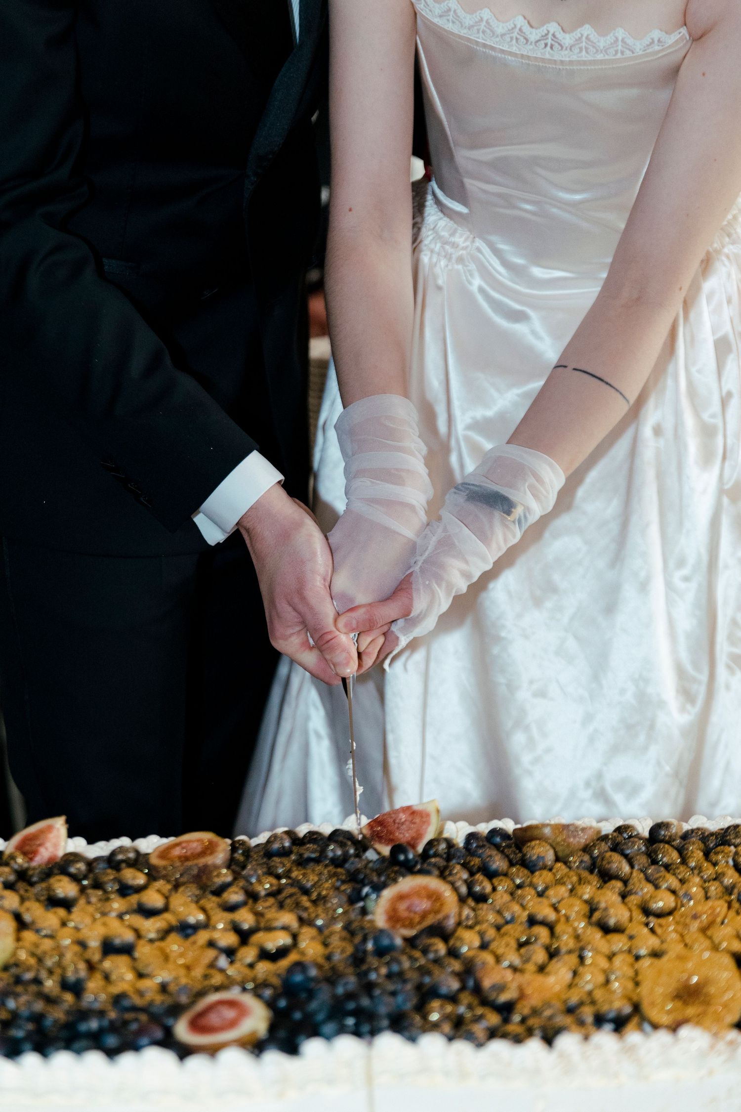 Close-up view of an elaborate dessert display featuring cookies and dark berries arranged in a decorative pattern.