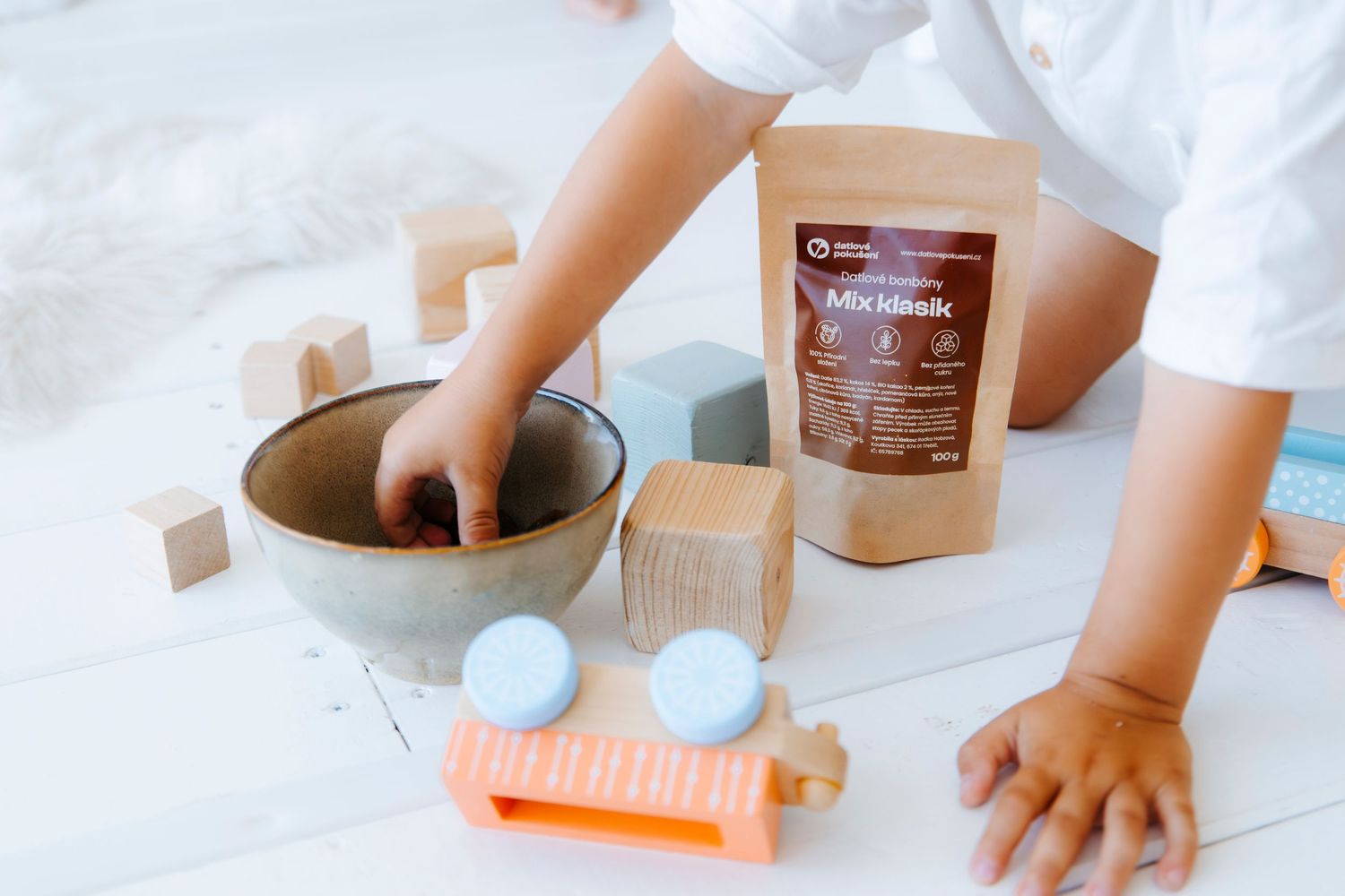 Hands preparing ingredients and mixing bowls on a white countertop for baking or cooking.