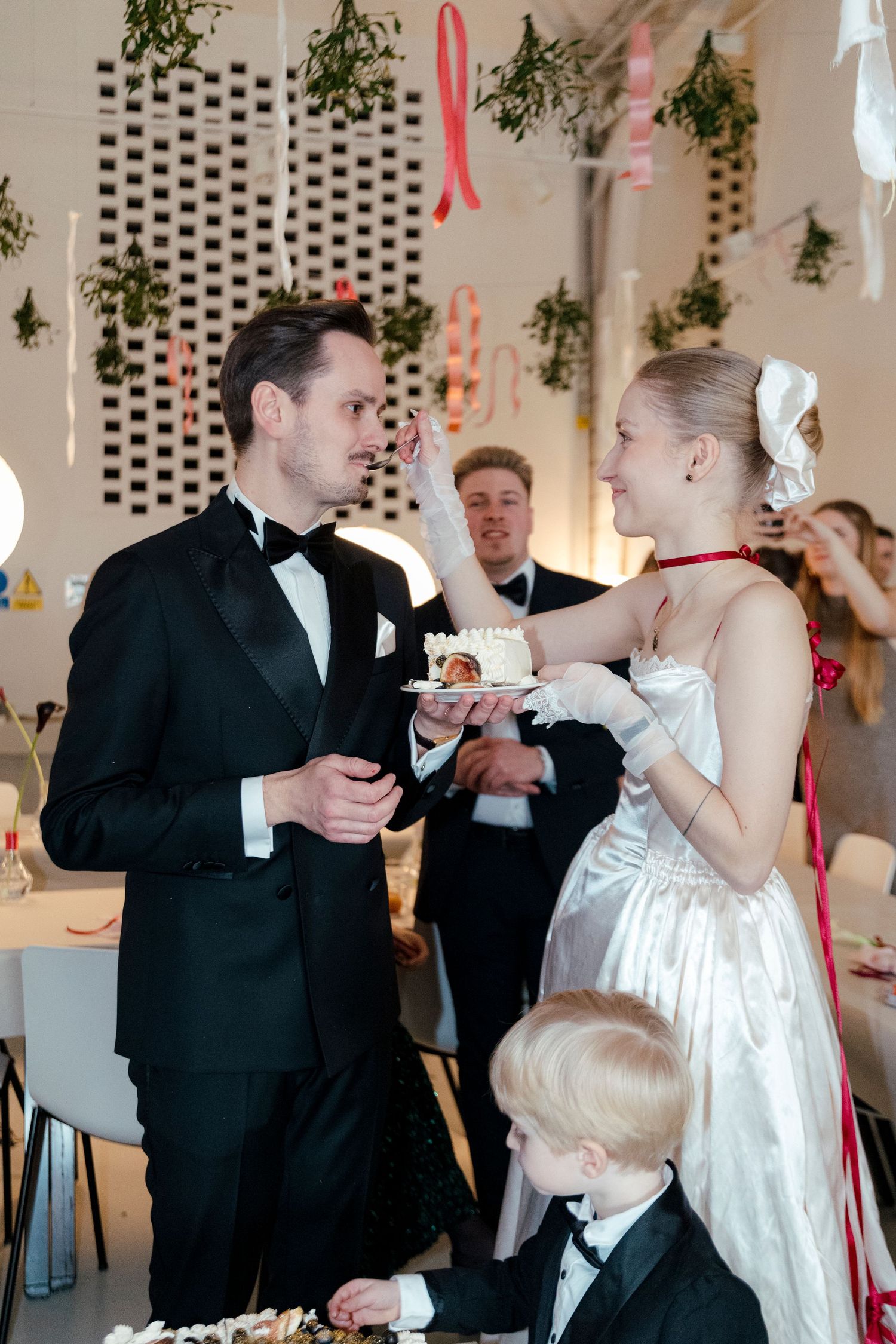 Wedding couple shares a celebratory moment while feeding each other dessert at their reception.