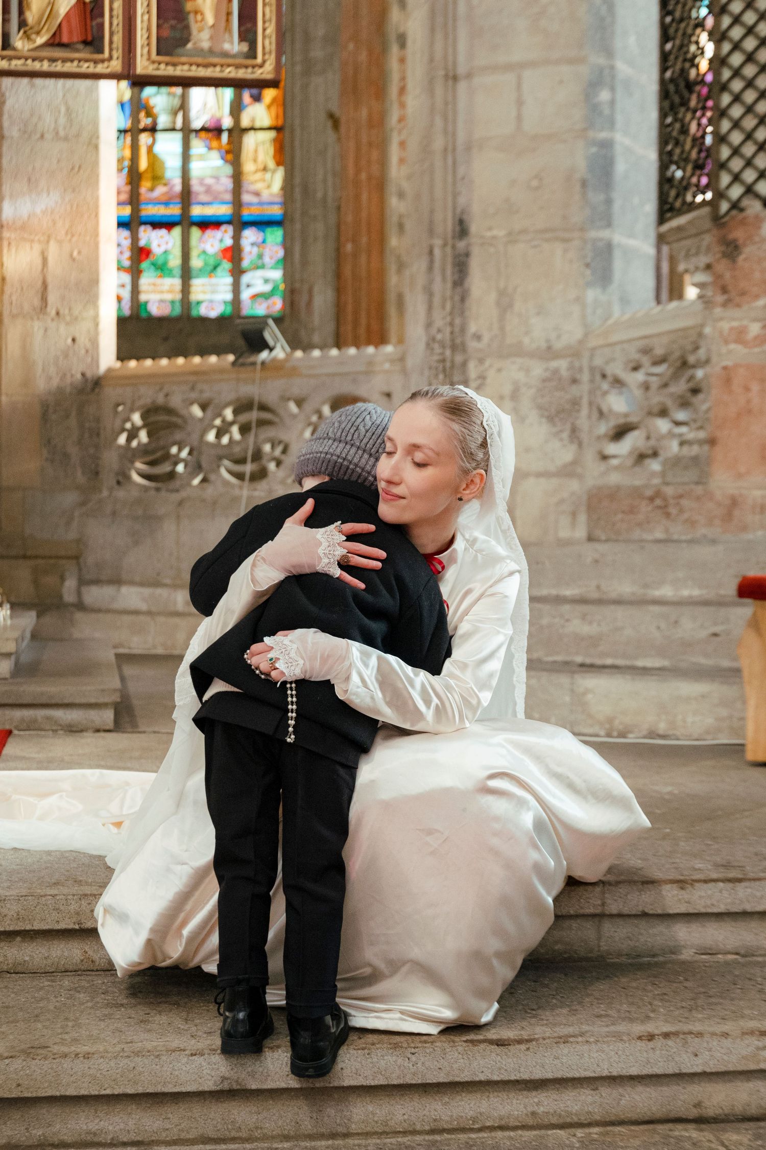 A heartwarming series of photos showing a young ring bearer falling asleep on church steps during a wedding ceremony.