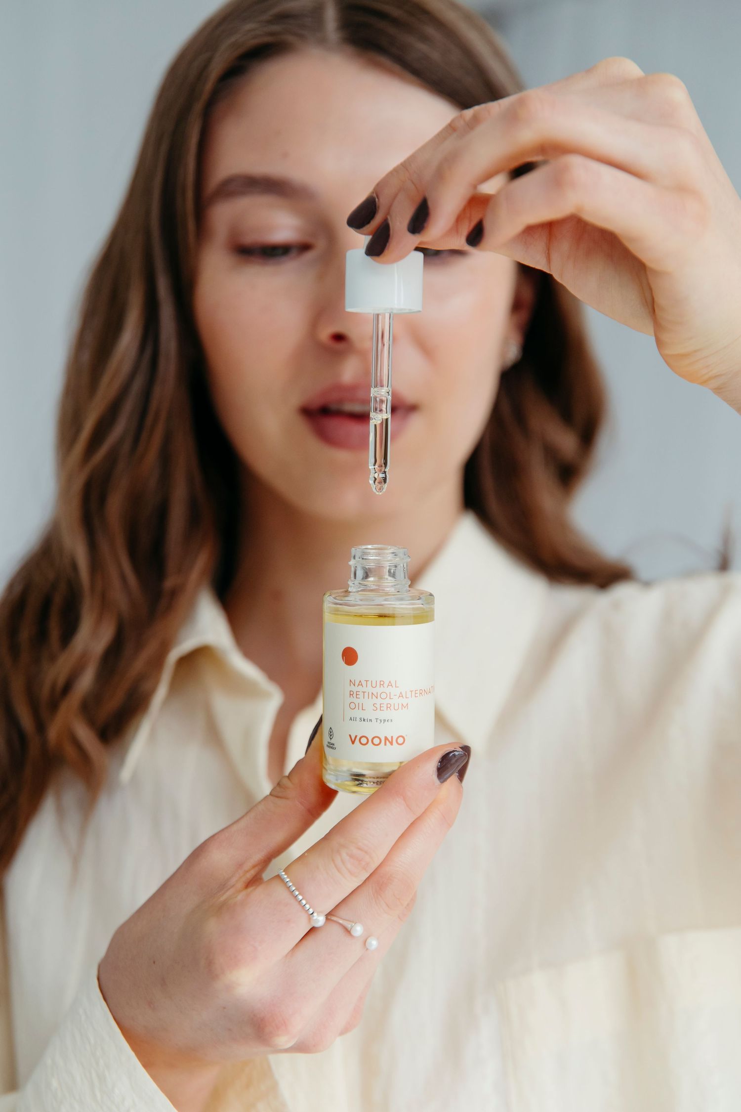 Natural skincare product being applied to hand against white background.