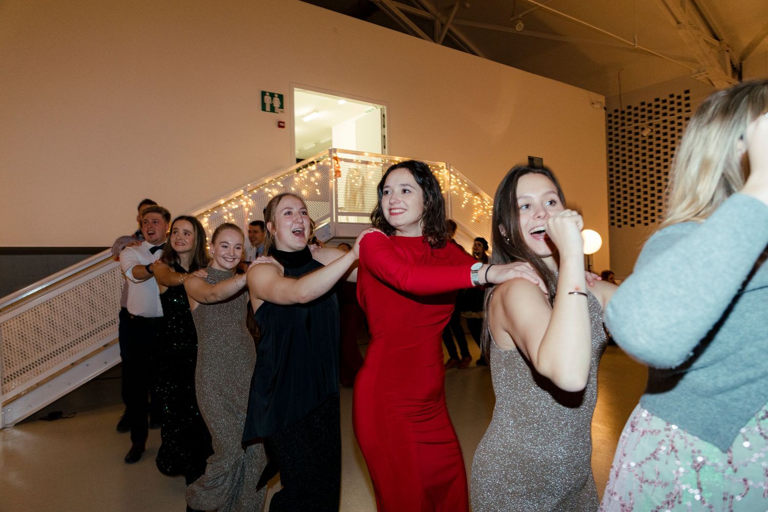 Group of people dancing and celebrating in a dimly lit indoor venue.