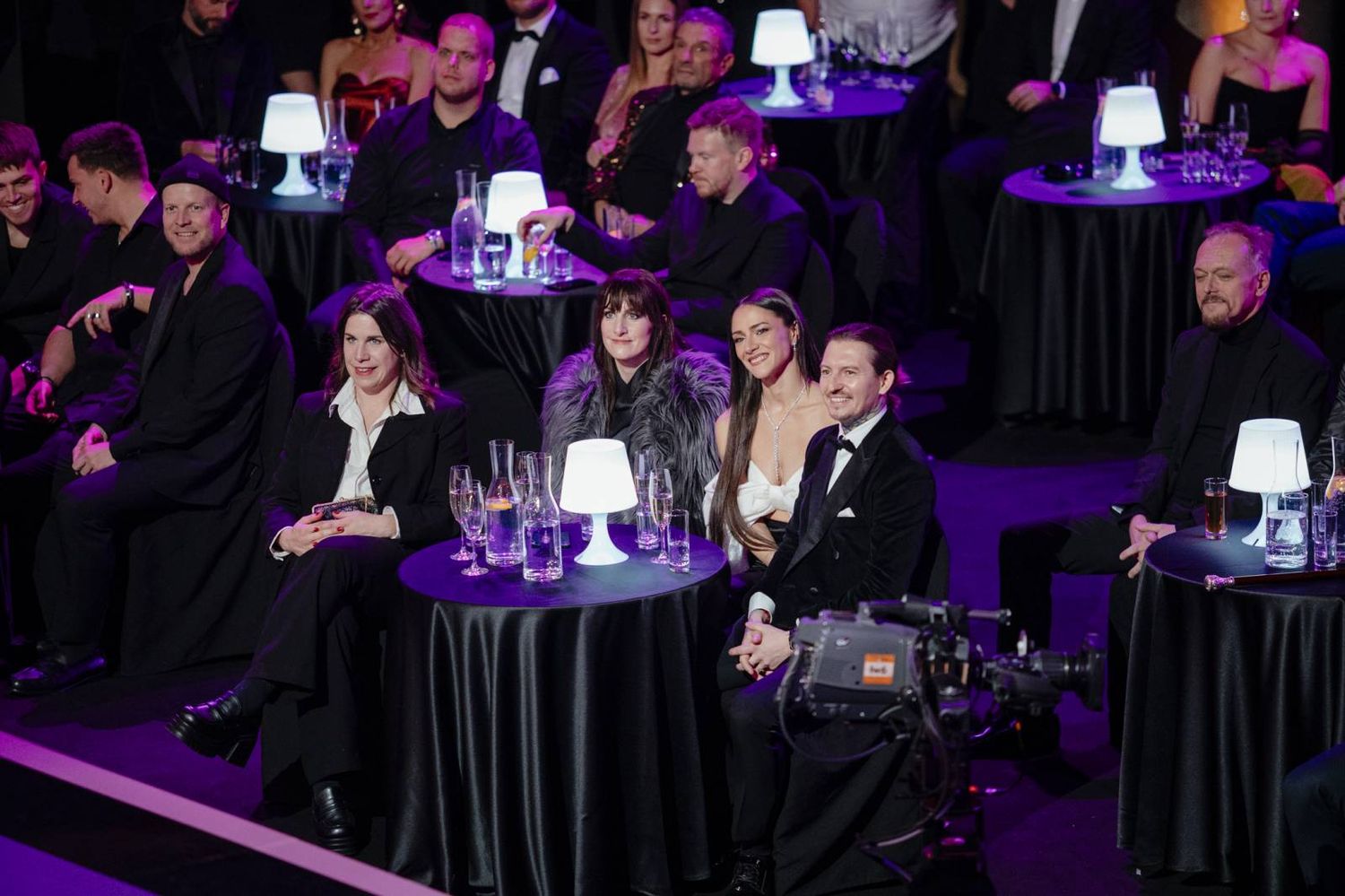 Entertainment event with tables and purple ambient lighting creating an elegant atmosphere.