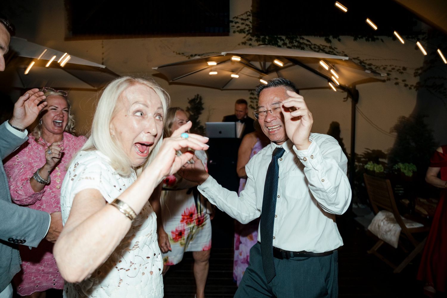 Wedding reception guests dancing and celebrating on the dance floor.