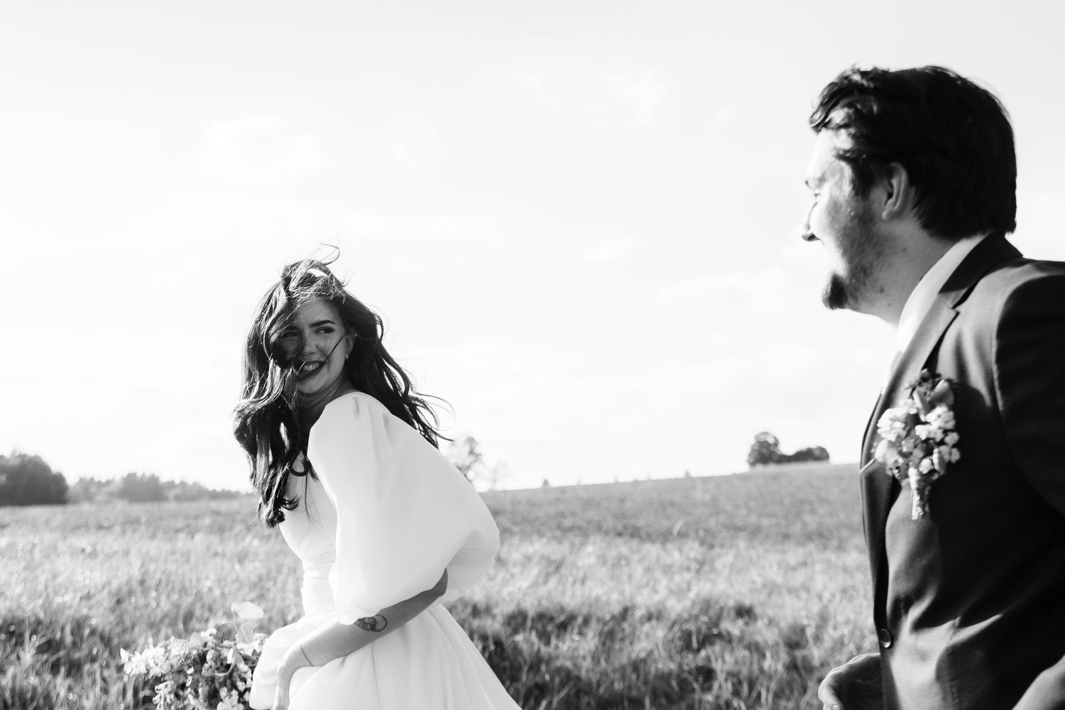 A series of candid black and white shots showing joyful moments in a sunny field.