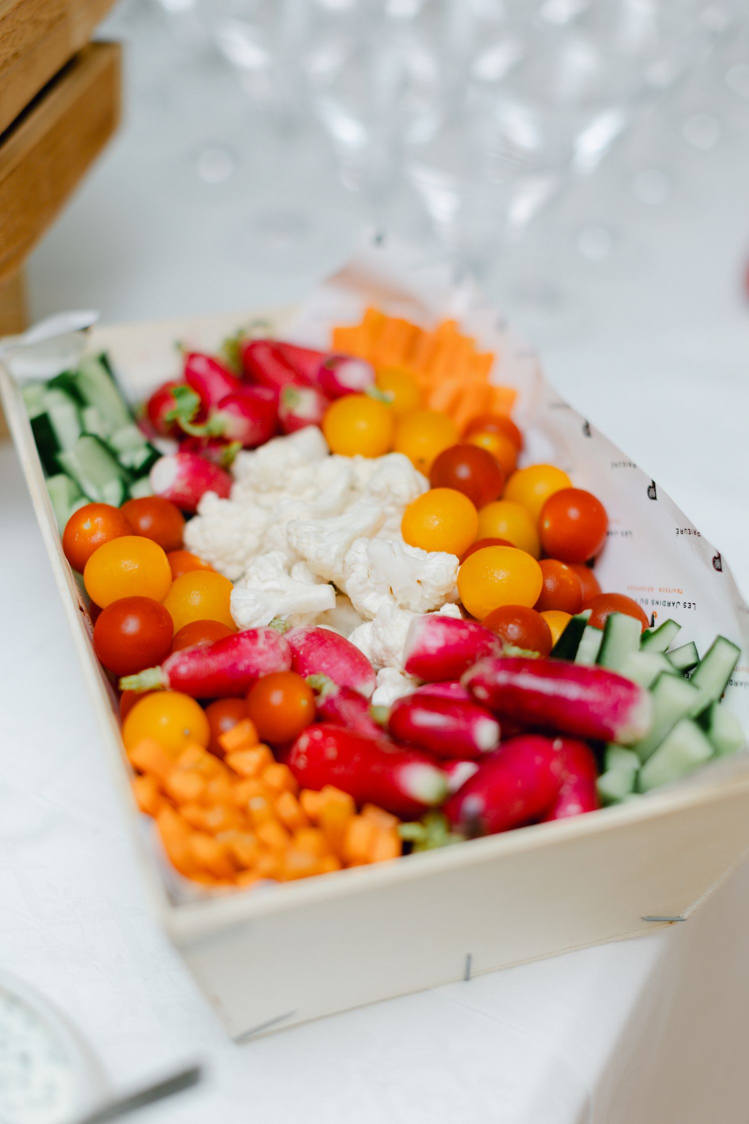 Plateau de légumes frais colorés avec tomates, concombres, radis et trempette au chou-fleur.