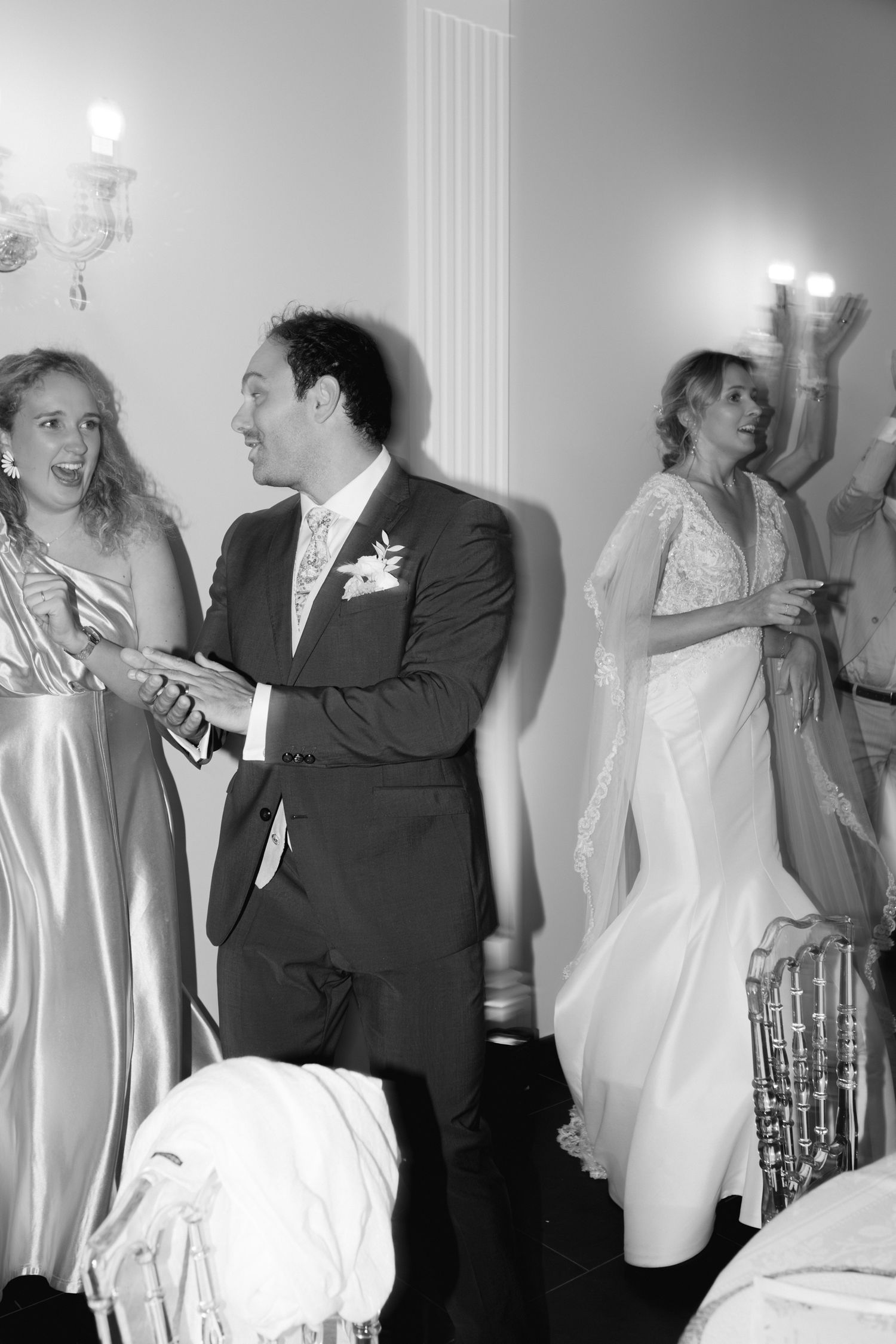 Photo en noir et blanc d'invités de mariage dansant et célébrant lors d'une élégante réception de mariage.