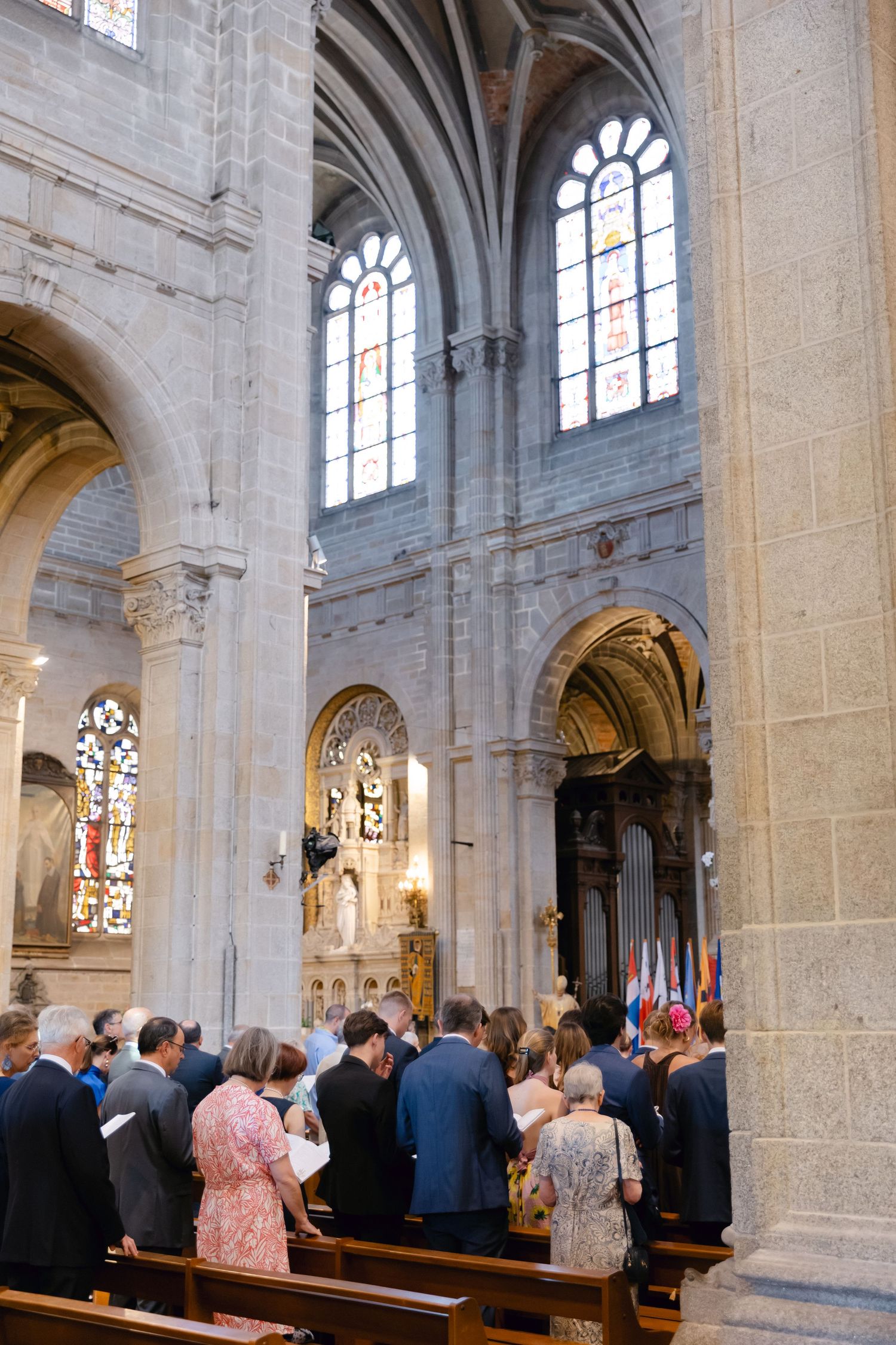 La congrégation s'est réunie à l'intérieur d'une grande cathédrale en pierre avec des plafonds voûtés et des vitraux lors d'une cérémonie re